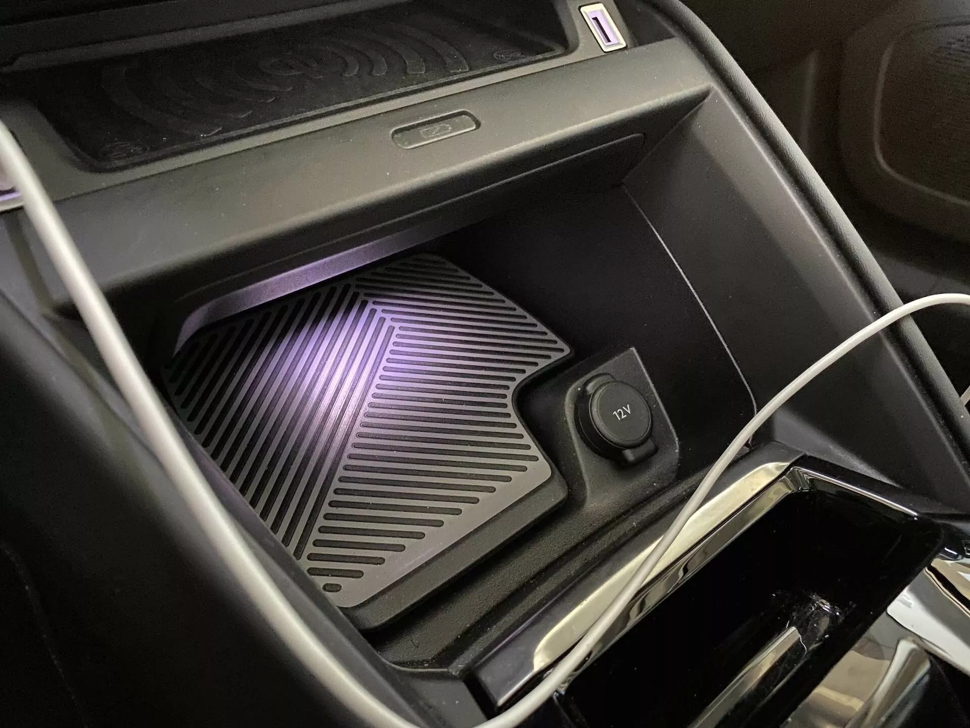 Detailní interiérový záběr Citroen C4 2020 (e-C4) na středovou konzolu zaměřující se na bezdrátovou nabíjecí podložku s LED osvětlením, povrch s žebrovanou texturou a přídavným úložným prostorem, nabízející možnosti kabelového i bezdrátového nabíjení.