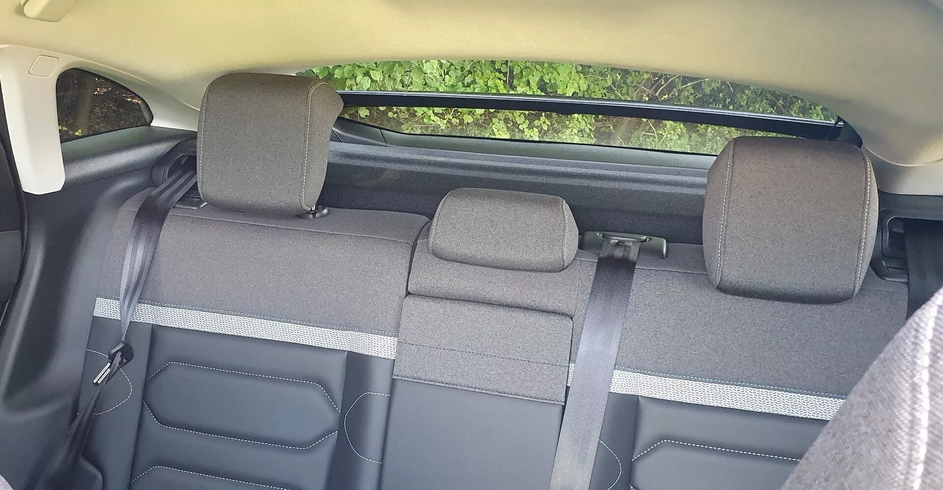 Interiér Citroënu C4 z roku 2020 se zaměřením na zadní sedadla pohledem od předních sedadel. Zadní lavice, rozdělená do tří sekcí se skládací funkcí 60/40, pojme až tři cestující. Látkové čalounění naznačuje standardní úroveň výbavy, s nastavitelnými hlavovými opěrkami pro vnější sedadla. Barevné schéma je dvoutónové s viditelnými plastovými prvky na bocích a krytech pásů. Není zde viditelná žádná pokročilá technologie, ale jsou přítomny standardní bezpečnostní prvky, jako jsou bezpečnostní pásy.