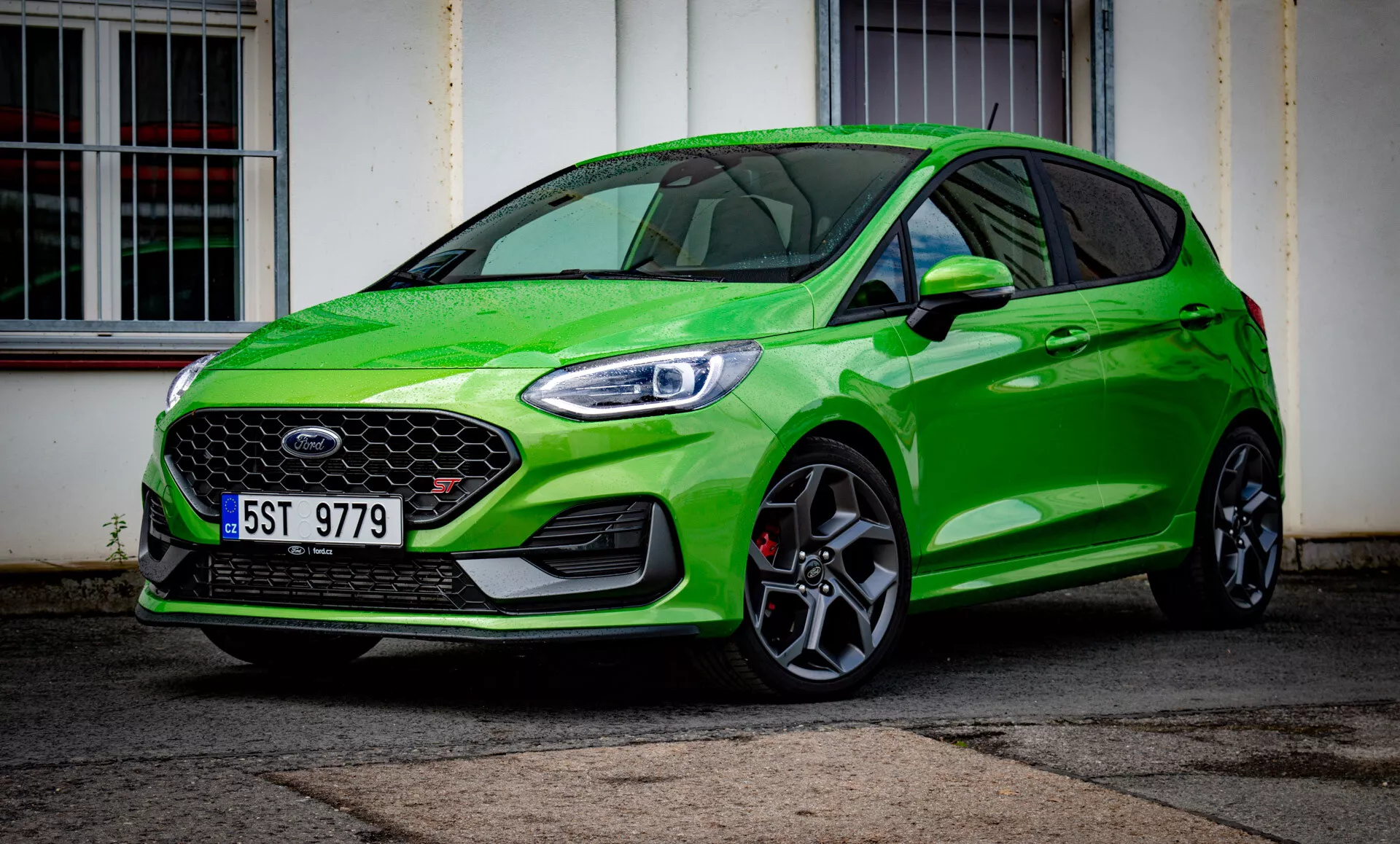 Hatchback Ford Fiesta 2022 ve výrazné zelené barvě, zobrazující přední design s LED světlomety, včelí pláství mřížkou, sportovními slitinovými koly a aerodynamickým profilem