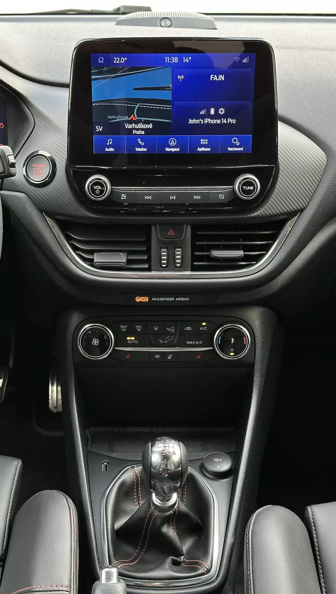 Interiér Ford Fiesta 2022 předvádějící dotykový infotainment systém, duální klimatizaci, manuální převodovku a luxusní kožené akcenty z pohledu spolujezdce