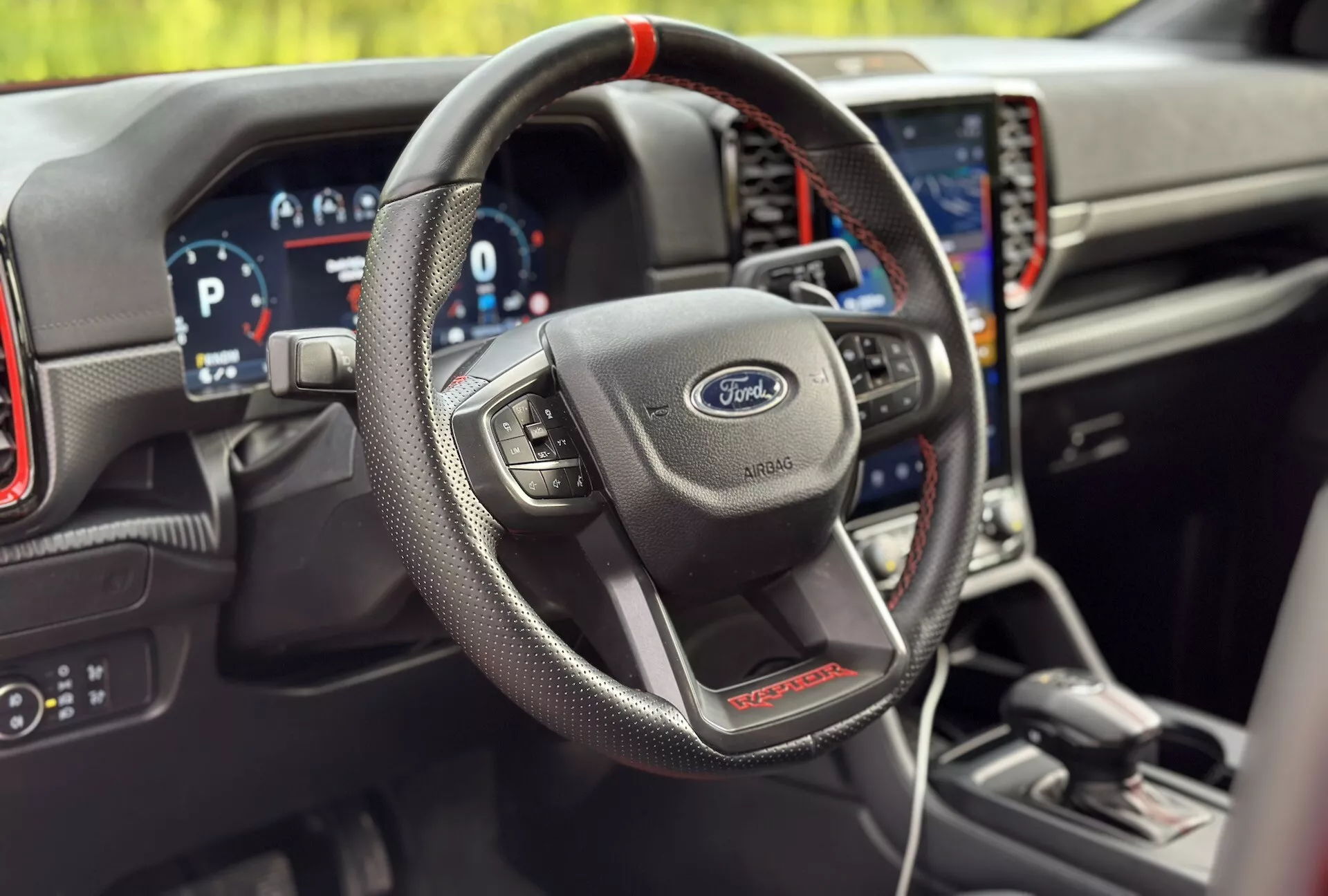 Interiér Ford Ranger 2022, zdůrazňující volant obalený kůží s multifunkčními ovládacími prvky, digitální přístrojovou desku a integrovaný navigační systém ve sportovní variantě ST