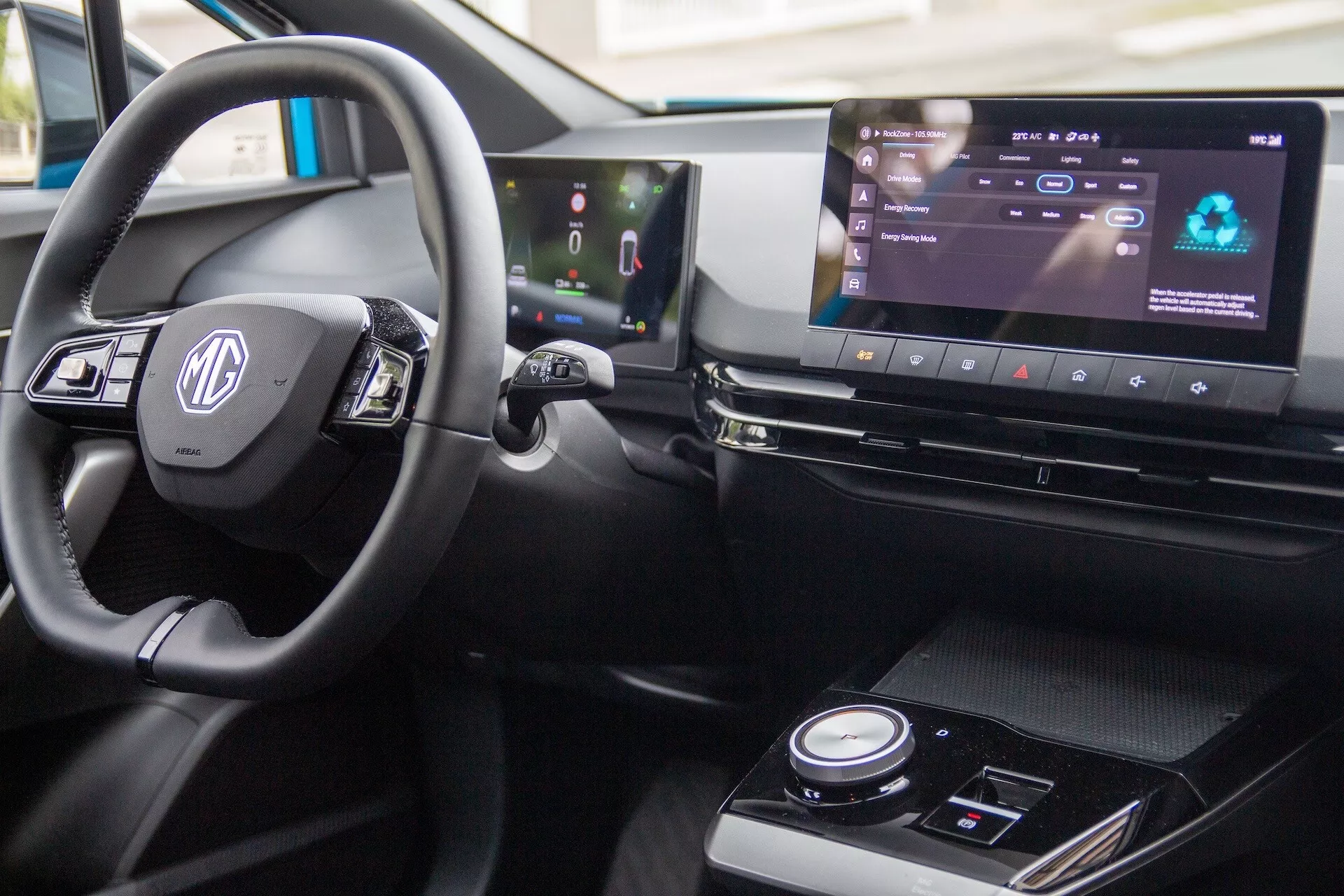 Detailní pohled na interiér MG MG4 2022, zahrnující volant s ovládacími prvky, digitální palubní desku a širokoúhlý infotainment systém v pravostranné konfiguraci