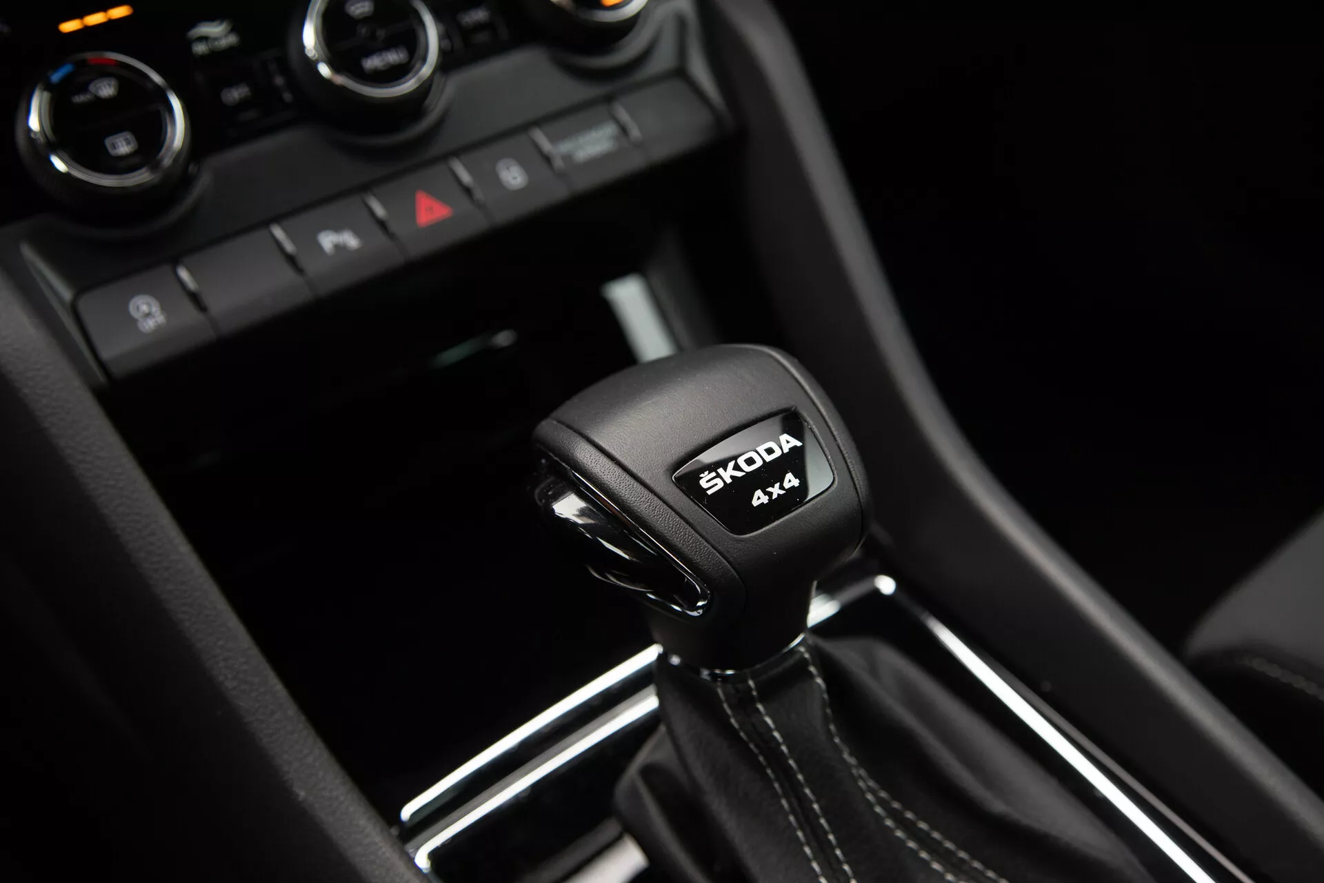 Automatická převodovka Škoda Karoq 2021 s označením systému 4x4 a logem Škoda, obklopená moderními detaily interiéru z lesklého černého a kovového obložení.