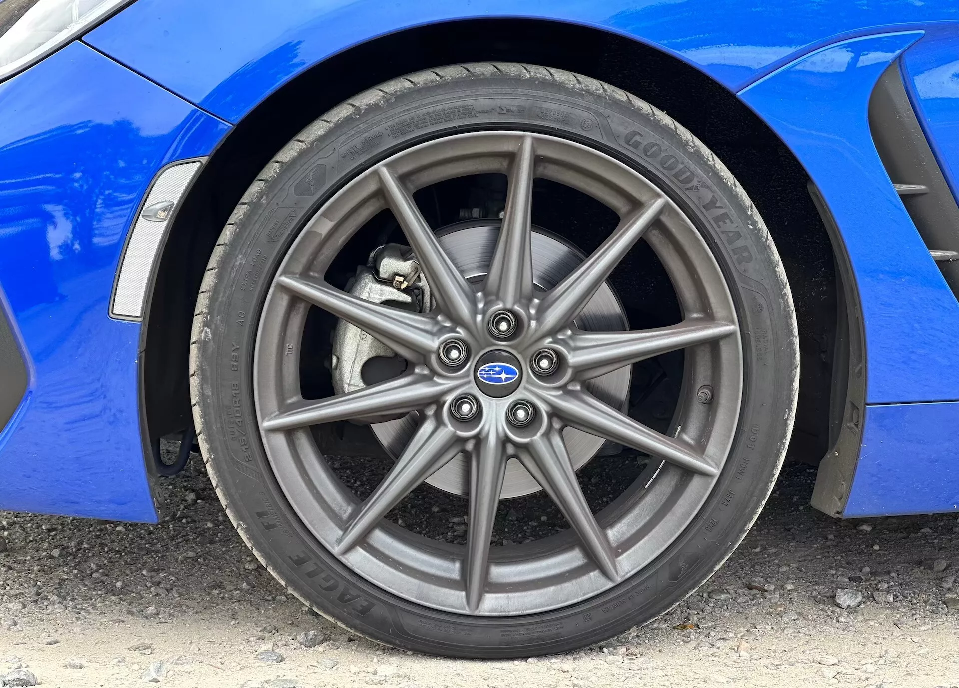 Detailní obrázek předního slitinového kola a pneumatiky Continental Subaru BRZ 2023 s viditelnou živou modrou karoserií