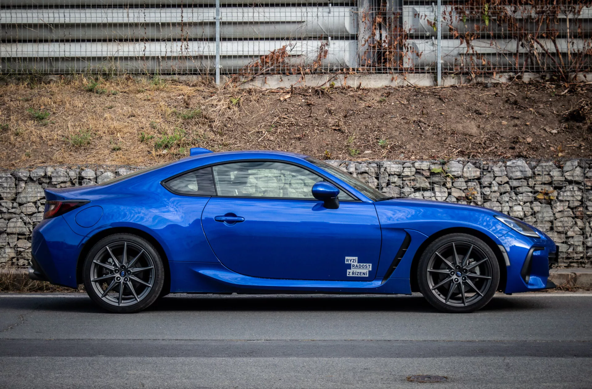 Subaru BRZ 2023 zaparkované v městském prostředí, předvádějící svůj elegantní design a živou modrou barvu