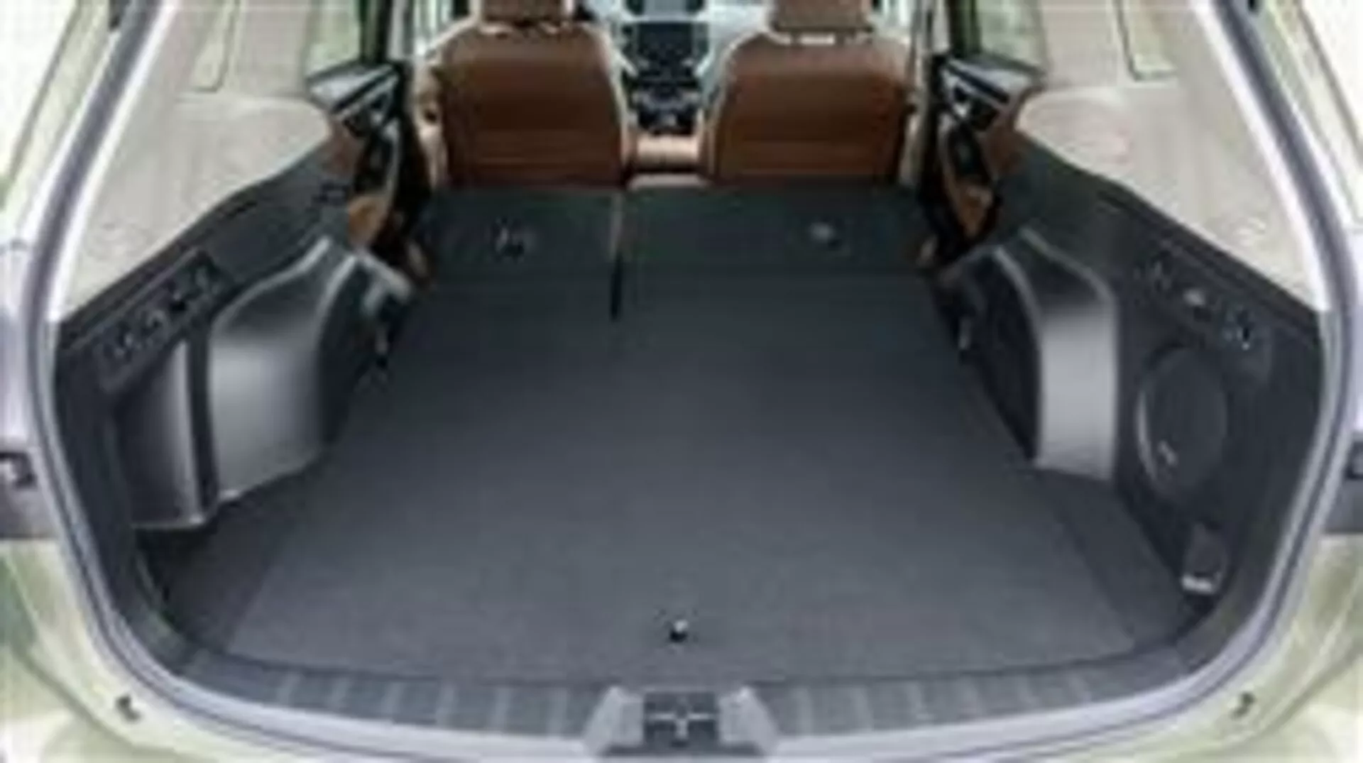 Prostor pro zavazadla Subaru Forester 2015 se sklopenými zadními sedadly, který ukazuje prázdný nákladový prostor a luxusní interiér z hnědé kůže, pohled z vyvýšené perspektivy