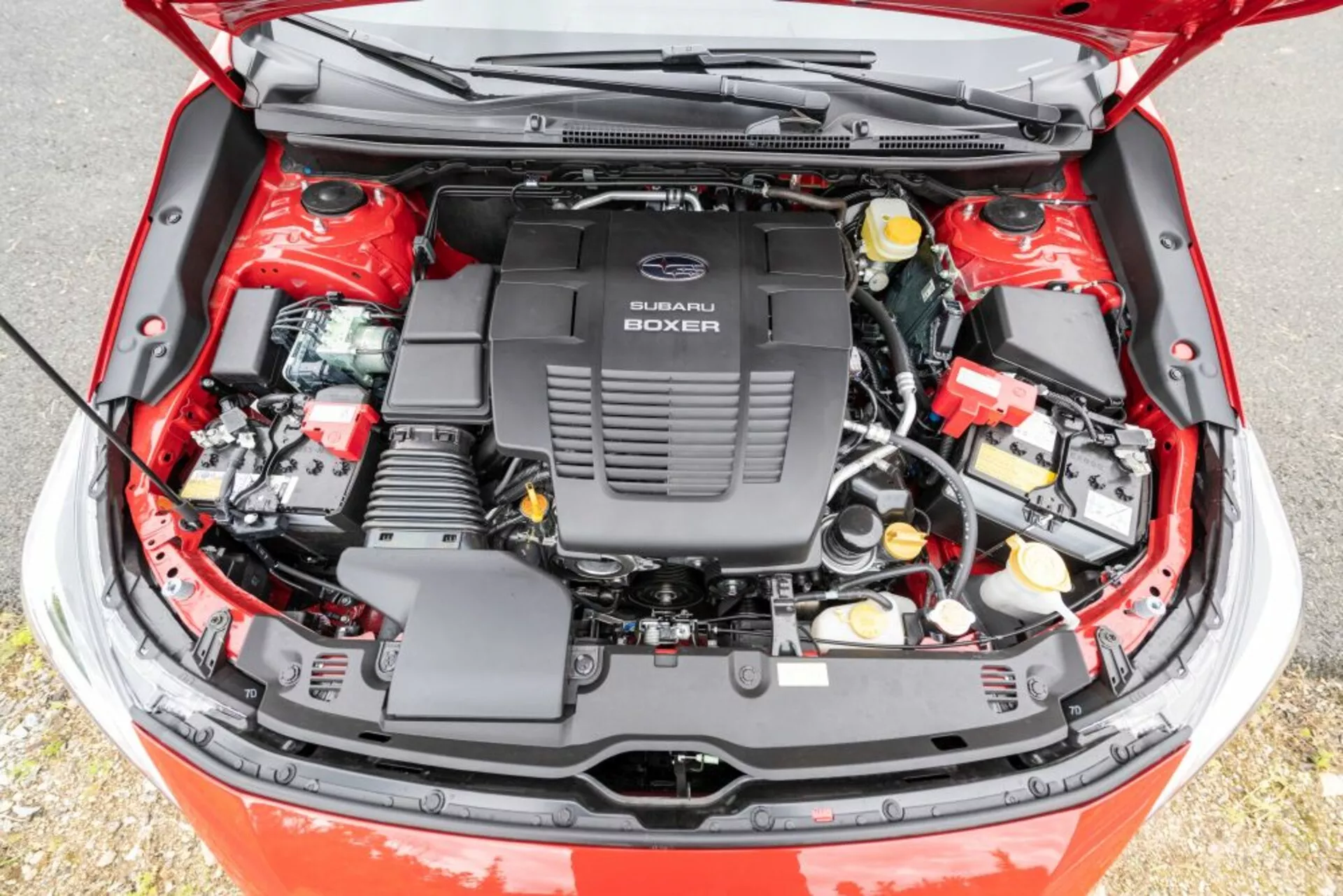 Podrobný pohled na otevřený motorový prostor Subaru Impreza 2018 s motorem Subaru Boxer, zobrazující mechanické a elektrické komponenty z vyvýšeného úhlu