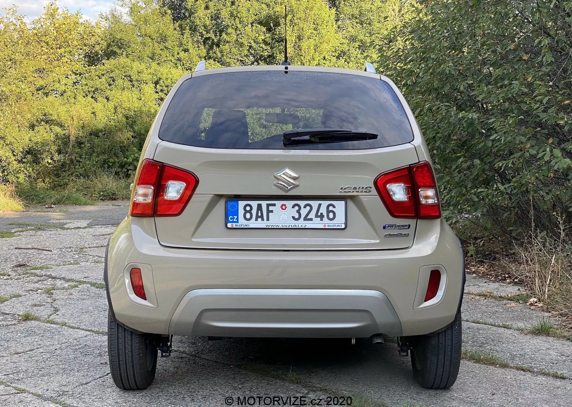 Zadní pohled na Suzuki Celerio, který zobrazuje jasné detaily včetně znaku Suzuki, značky CELERIO, vertikálních světelných klastrů, jednoduchého zadního nárazníku, evropské poznávací značky, zadního skla s odmrazovačem a horní brzdovou lampou, stěrače, antény na střeše, ocelových disků se středovými kryty a jednoduchého výfukového systému, ilustrující design základního městského vozu.