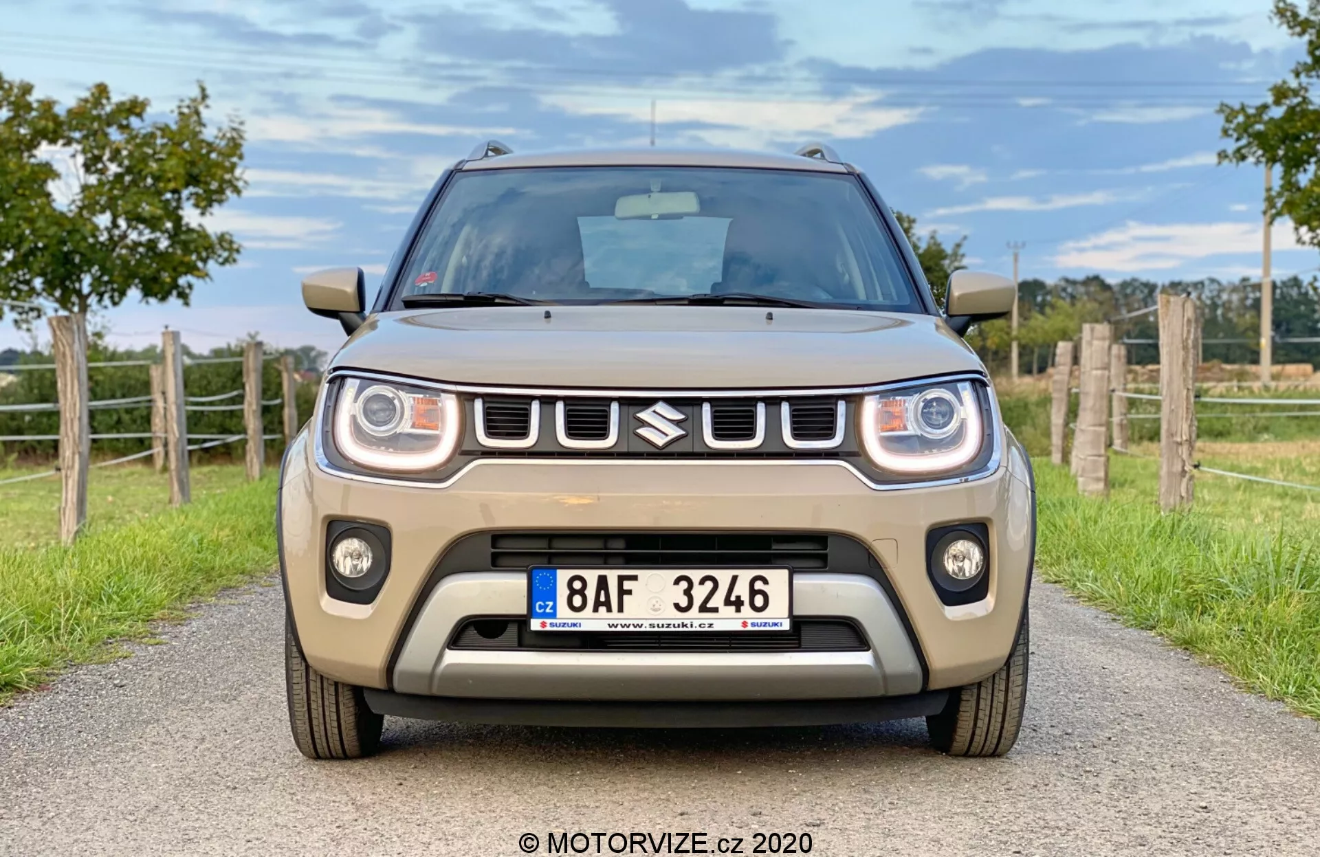 Pohled z boční strany na Suzuki Ignis 2020 1.2 Dualjet Hybrid Club ve městském prostředí, zdůrazňující kompaktní design, moderní světlomety a výraznou masku chladiče.