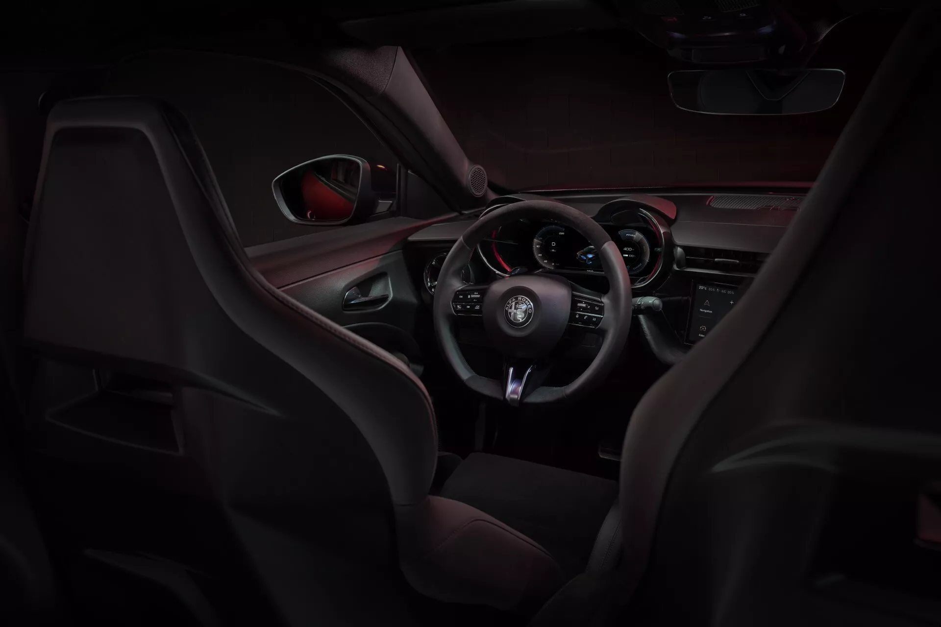 Interiér Alfa-Romeo Junior (966) na rok 2024 s sportovními sedadly z kůže a síťoviny, multifunkčním volantem oblečeným v kůži a palubní deskou orientovanou na řidiče s červeným akcentním osvětlením