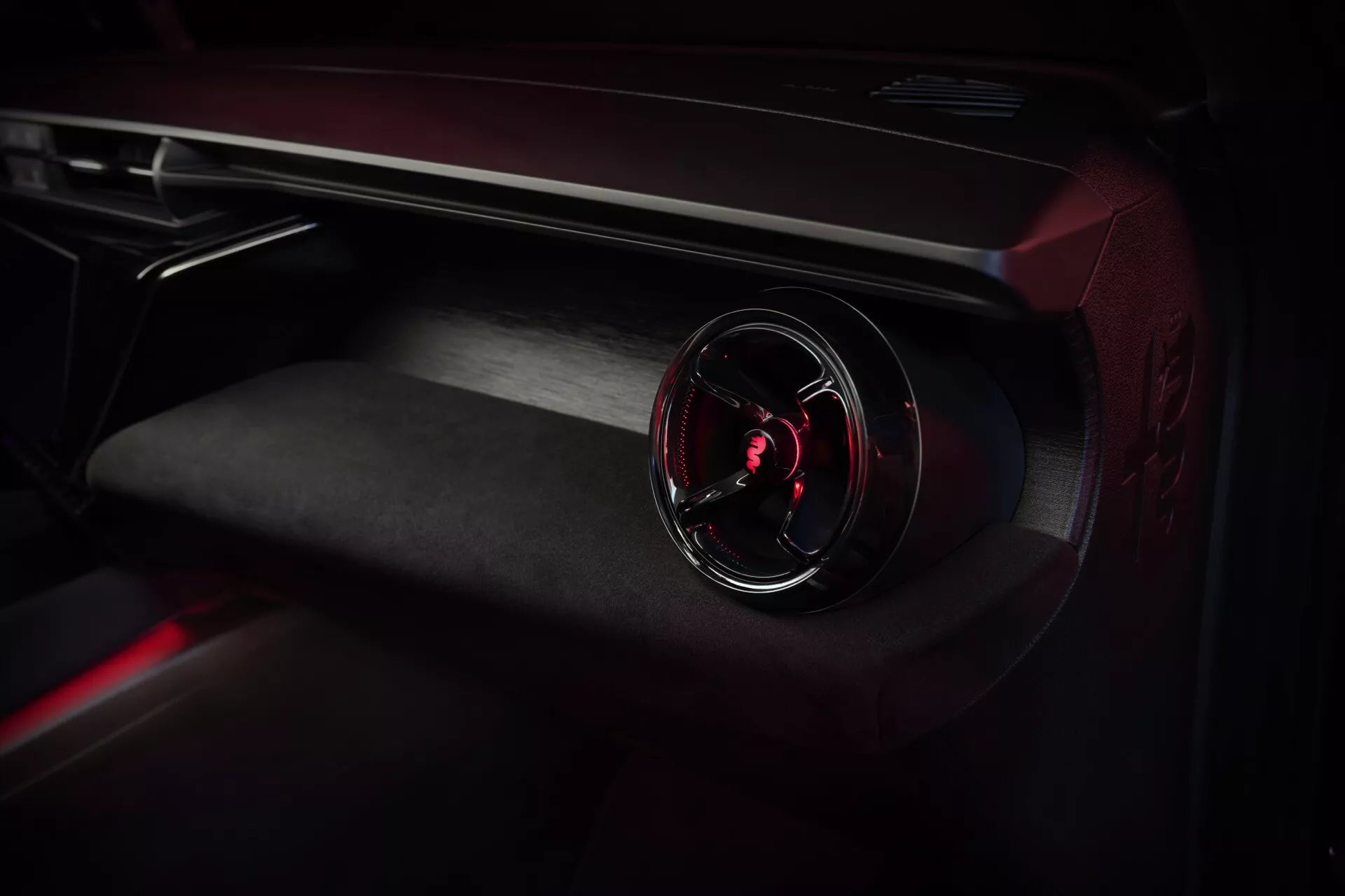 Detailní pohled na interiér Alfa-Romeo Junior 2024 se zaměřením na palubní desku na straně spolujezdce s osvětlenou ventilační mřížkou a prvotřídními materiály