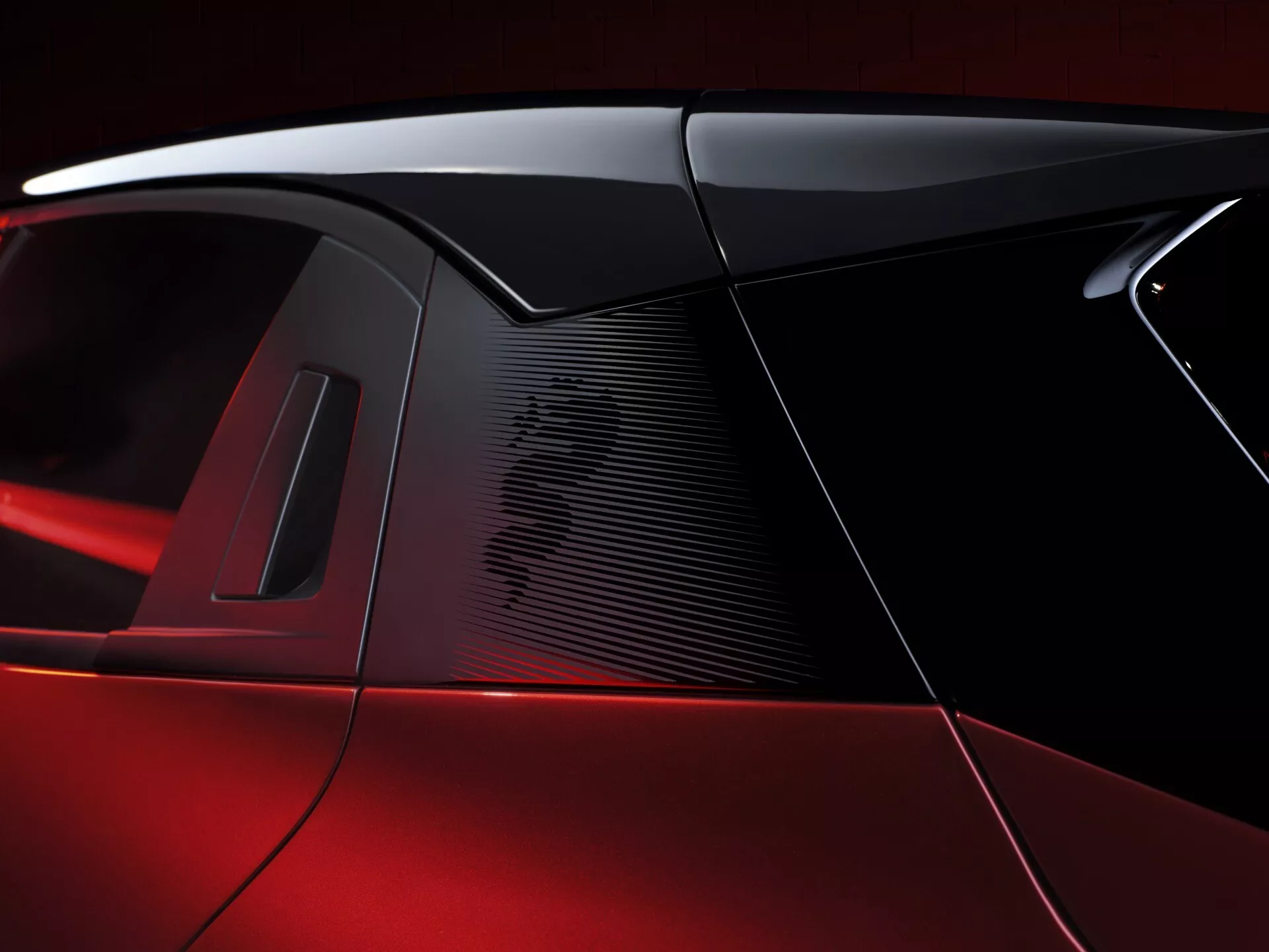 Detailní pohled na C sloupek Alfa Romeo Junior 2024 s perleťově červeným lakem, elegantním designem zadního okna, výkonnostním vzduchovým vstupem a potenciálním panoramatickým střešním oknem, zdůrazňujícím luxus a sportovní designové prvky.