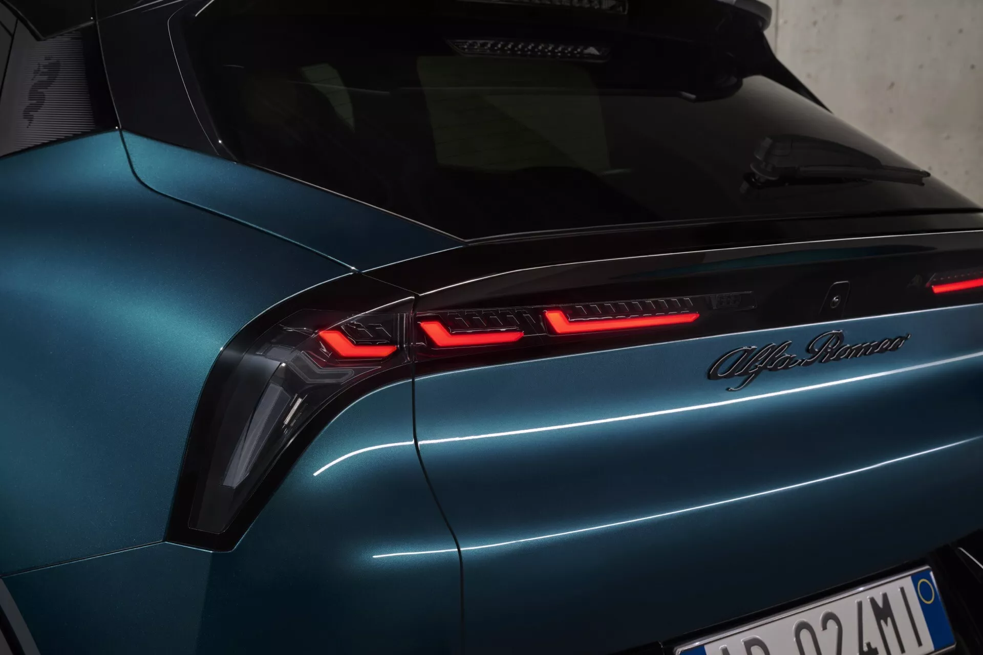 Detailní úhlový pohled na zadní část současného modelu Alfa Romeo s LED zadními světly a metalickým modrým lakem