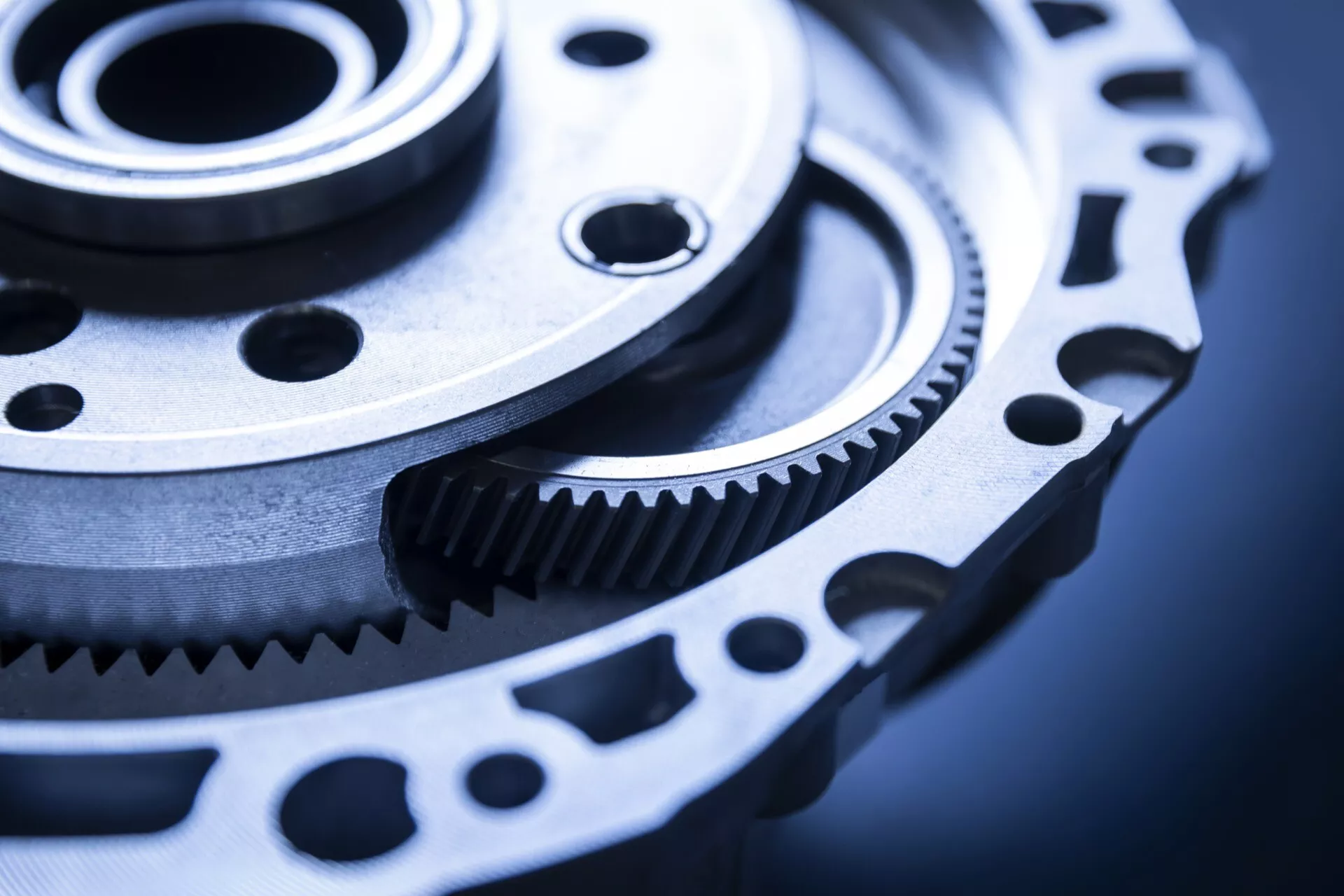 Detailně zpracované ozubené kolo a kolečko přesné mechaniky, pravděpodobně pro automobilové využití, prezentující jemné obrábění a potenciál pro přenos síly v chladném, průmyslovém prostředí