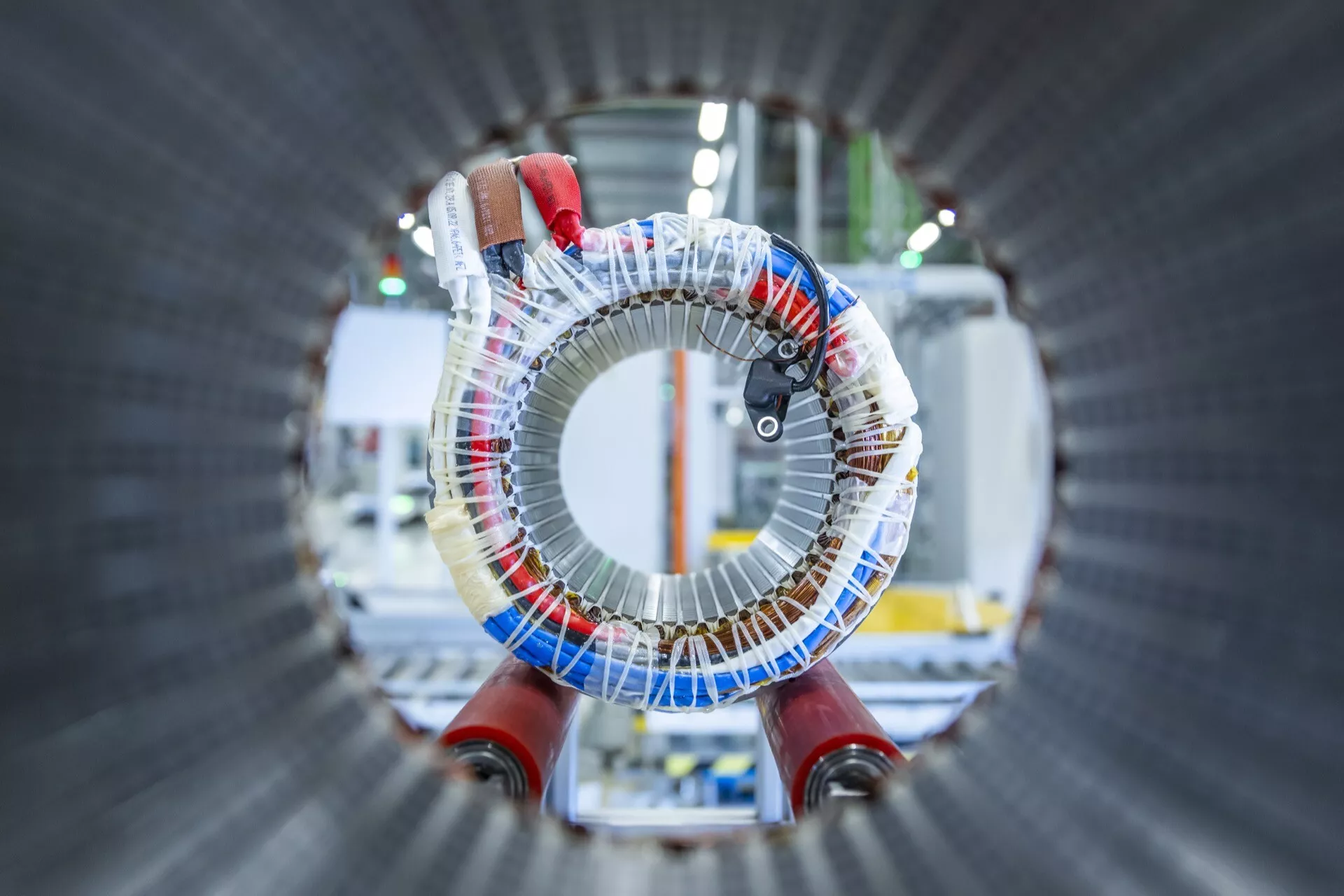 Detailní pohled na komponentu statoru pro elektrický motor v Audi Q8 e-tron 2023 s měděnými vinutími a kovovým jádrem v průmyslovém prostředí