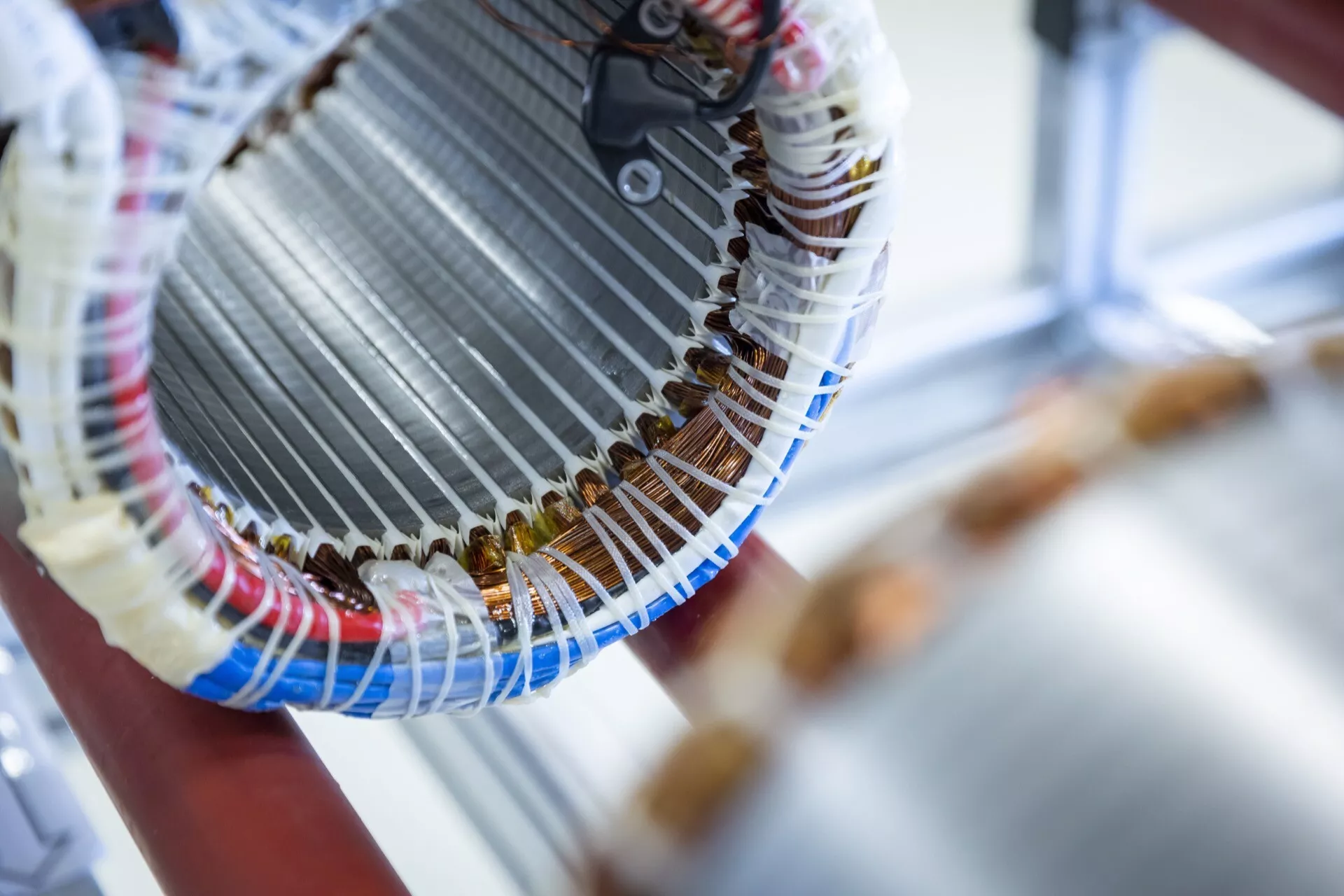 Detailní pohled na stator elektrického motoru s důrazem na měděné vinutí a izolaci, zdůrazňující řemeslné zpracování konstrukce motoru