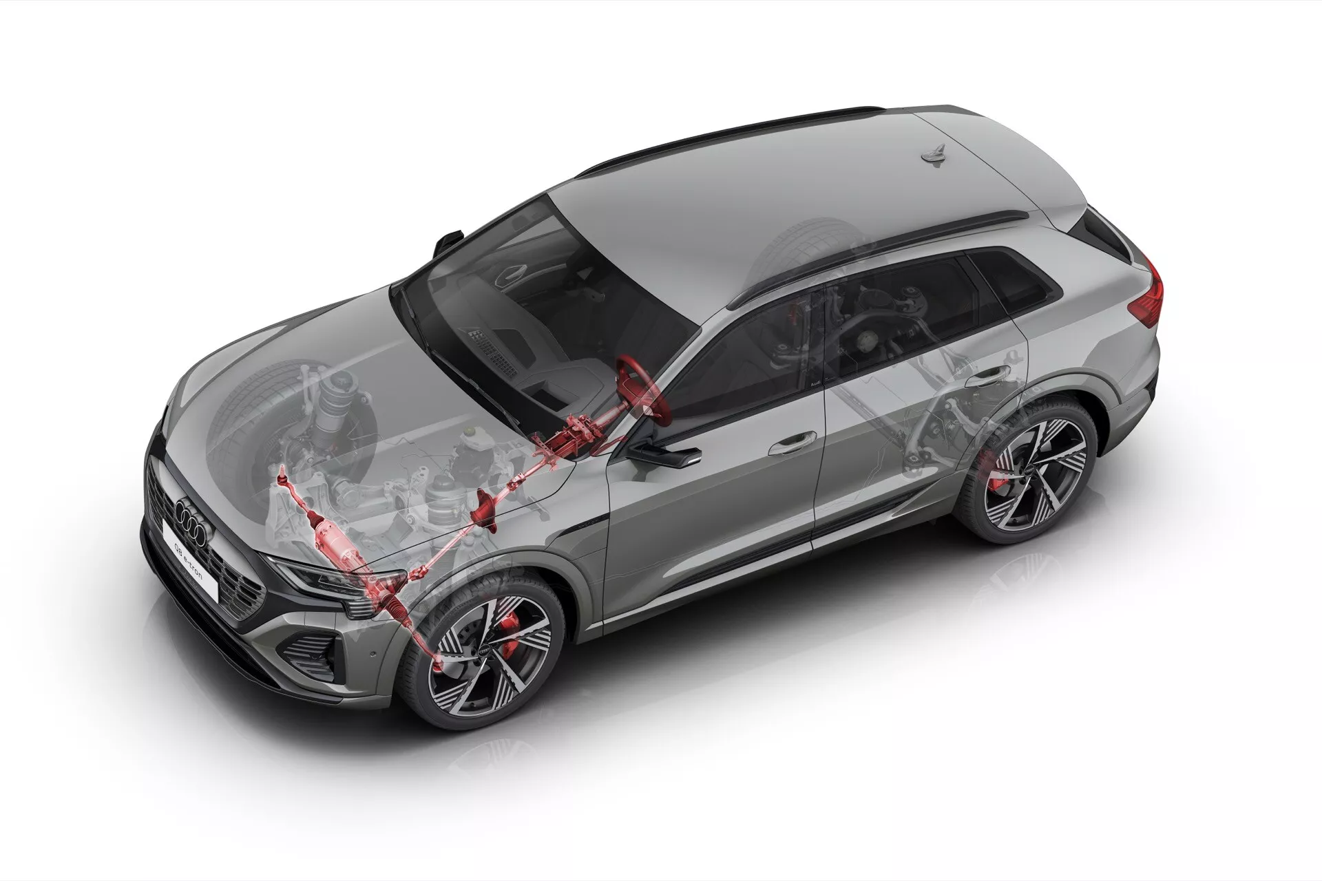 Šedé crossover SUV Audi Q8 e-tron 2023 v záběru shora ukazující střešní okno, střešní ližiny, anténu, aerodynamický design kapoty, pravé slitinové kola s nízkoprofilovými pneumatikami a pokročilé bezpečnostní funkce