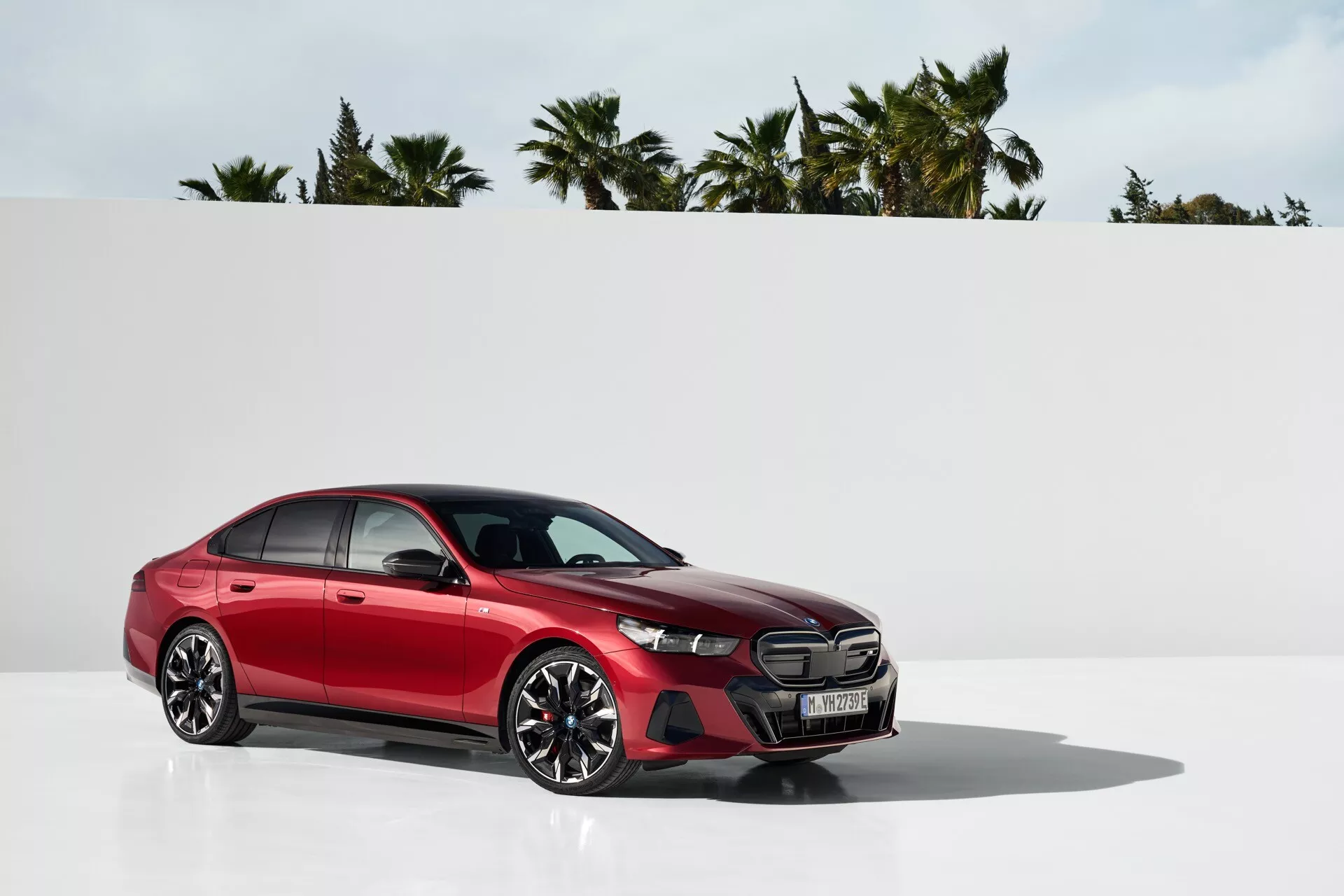 Moderní sedan BMW řady 5 z roku 2023 (G60-G61) v profilovém pohledu s odrazivým povrchem a minimalistickým pozadím zvýrazňujícím přední mřížku, LED světlomety, slitinová kola a elegantní design