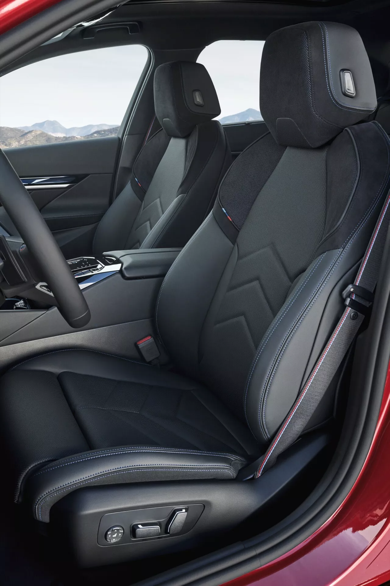 Interiérový pohled na BMW řady 5 2023 (G60-G61) se zaměřením na sportovní přední sedadla s čalouněním z černé kůže a charakteristickým prošíváním, elektronické nastavení sedadel a moderní středovou konzolu, zachycené z úhlové perspektivy řidičovy strany.