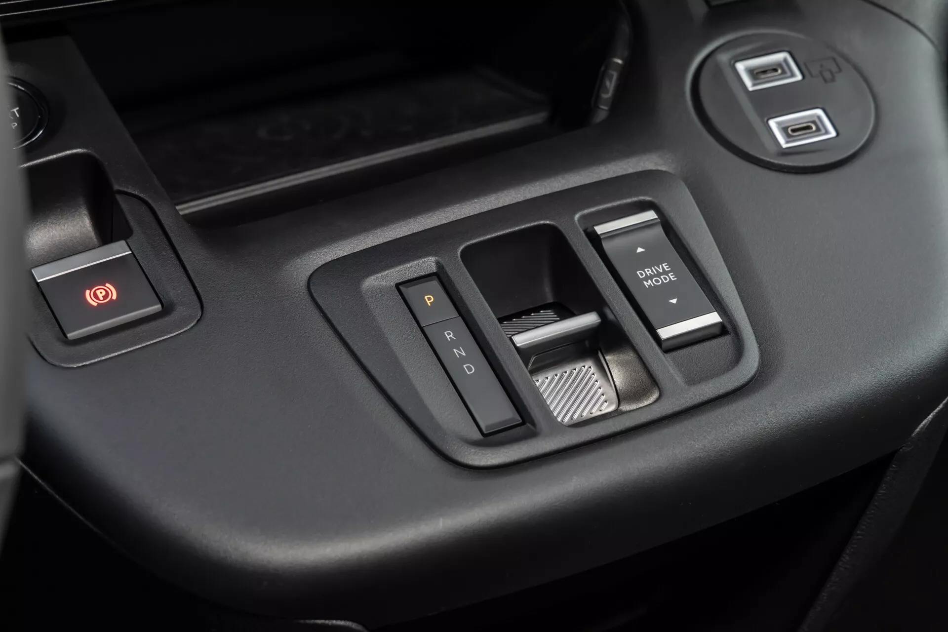 Detailní pohled na interiér Citroen Berlingo 3. generace facelift 2024 se zaměřením na ovládací panel dveří řidiče s tlačítky pro varovné světlo, ovládání oken a zrcátek