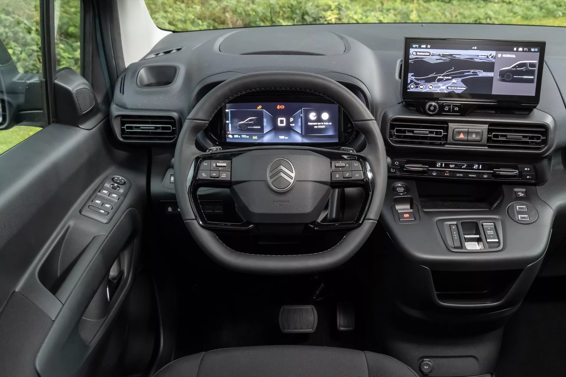 Interiér Citroen Berlingo 2024 (facelift 3. generace) ukazující perspektivu řidiče na digitálně orientovanou palubní desku, obsahující multifunkční volant se třemi rameny, digitální přístrojový panel, dotykový informačně-zábavní systém a vysoce kvalitní materiálové dokončení.