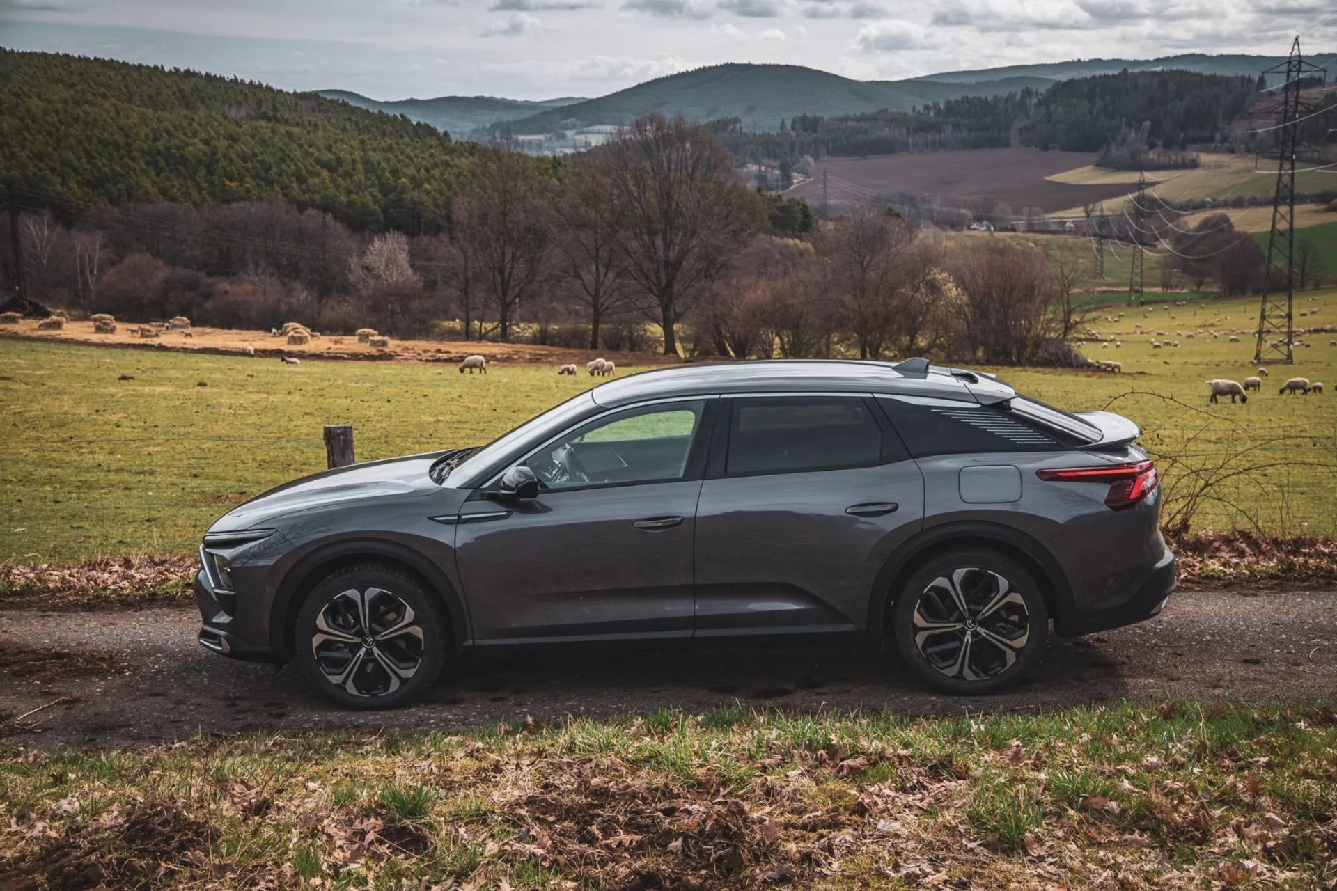 Citroën C5-X 2022 v elegantní stříbrné barvě, předvádějící svůj inovativní design a technologické funkce na jasný den