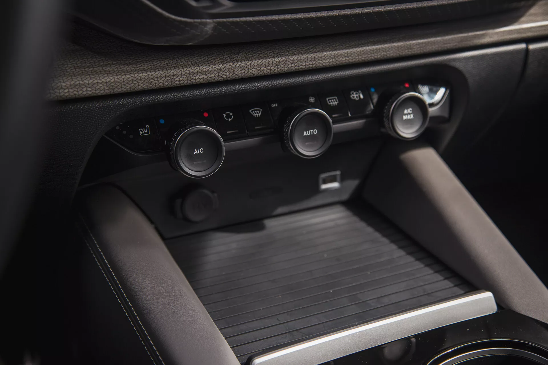 Detailní pohled na interiér Citroen C5-X 2022, zobrazující středovou konzolu s ovladači klimatizace a konzolí řadicí páky, zdůrazňující pokročilý klimatický systém vozidla, řešení pro uložení věcí a prémiové materiály.