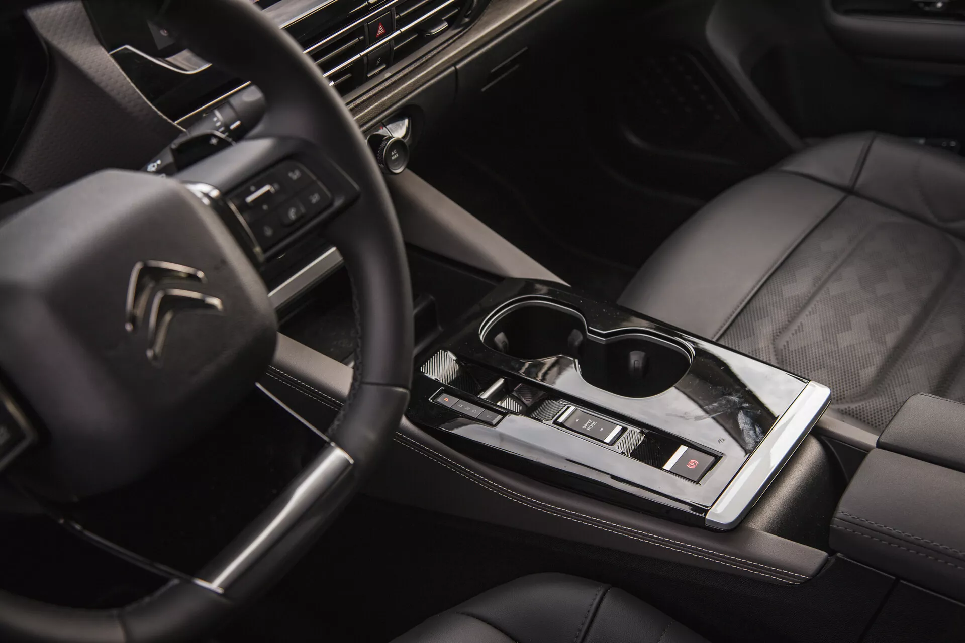 Interiér Citroën C5-X 2022 s multifunkčním volantem s logem, high-tech palubní deskou s infotainment systémem, elegantní automatickou řadicí pákou, ovládáním klimatizace, sedadly potaženými kůží s kvalitním prošíváním a dotekem životního stylu s brýlemi na lesklé středové ploše