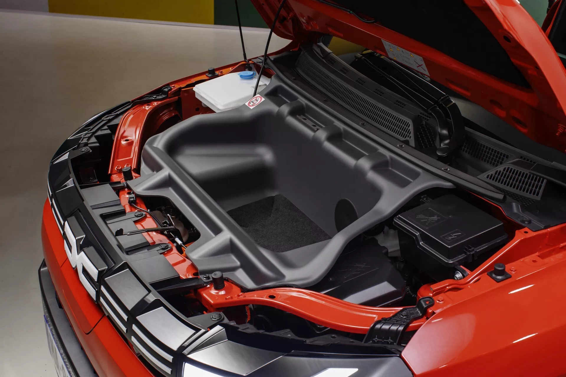 Detailní pohled na prostor motoru Dacia Spring 2024 (1. generace facelift) s elektrickým motorem a součástmi vysokého napětí, prezentující technologii EV