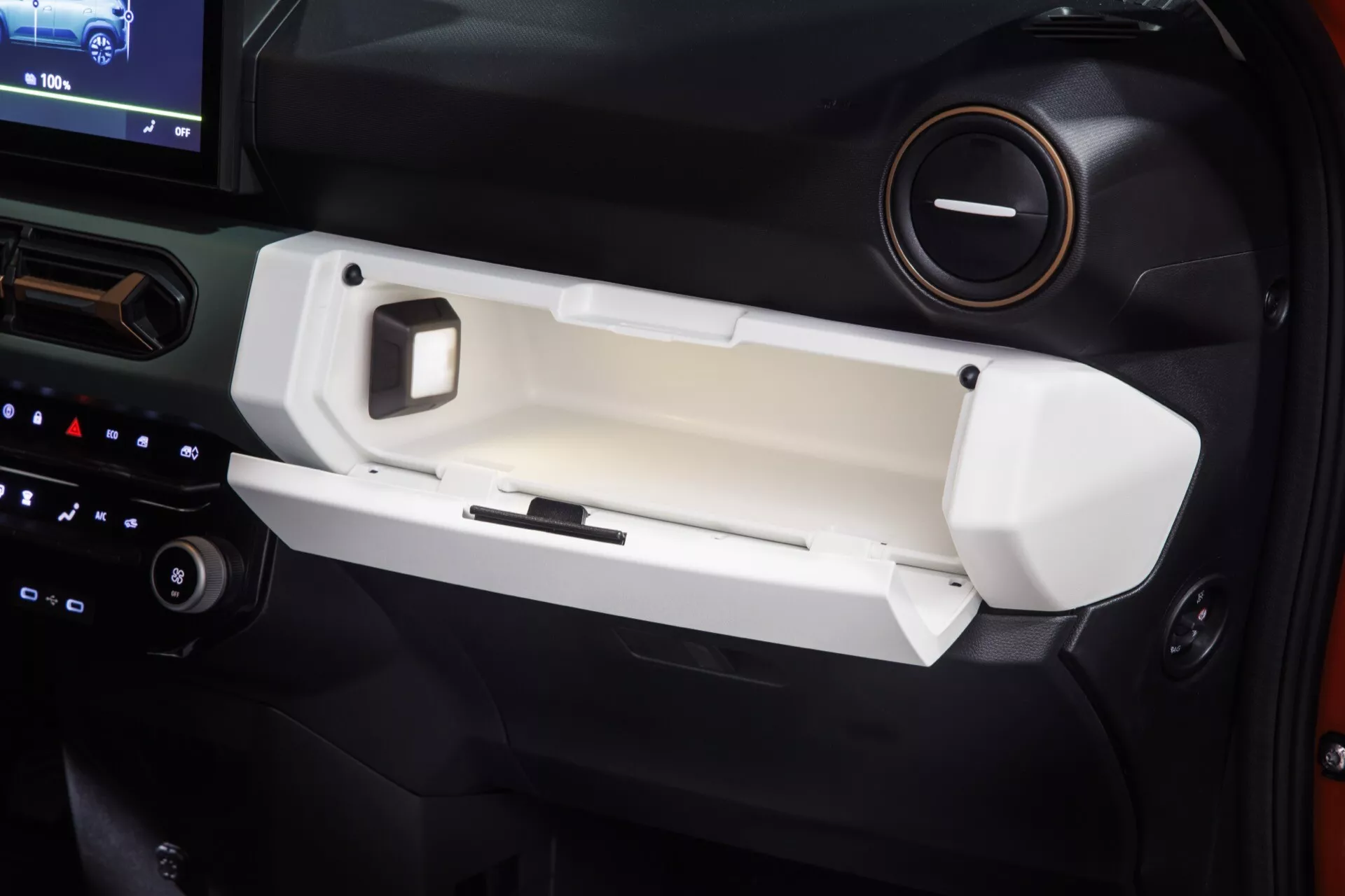 Interiér Dacia Spring 2024 (1. generace - Facelift) se zaměřením na dveře na straně spolujezdce, detaily odkládacího prostoru, chromové kličky, ovládací tlačítka a design smíšených materiálů.