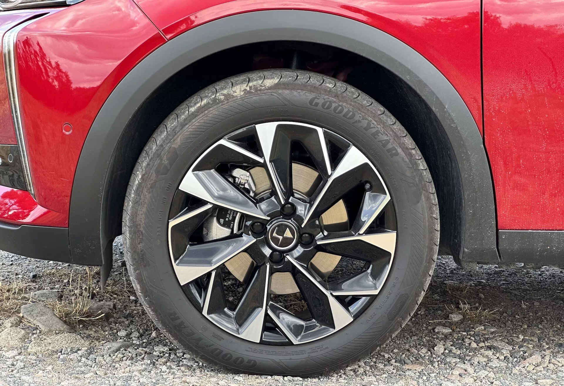 Detailní snímek předního kola a pneumatiky DS 3 E-TENSE 2023 s moderním slitinovým ráfkem s více paprsky a dezénem celoroční pneumatiky Goodyear, naznačující off-road schopnosti SUV.