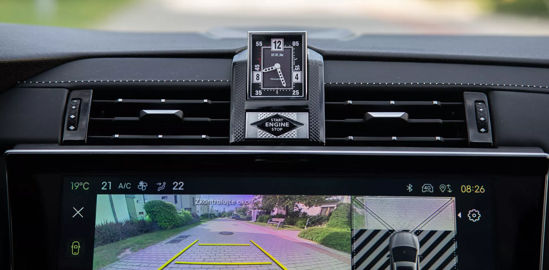 Interiérový pohled na DS Automobiles DS-7 2022 s palubní deskou, luxusním analogovým hodinkami a centrálním displejem infotainment systému s kamerou pro couvání a funkcí asistence při parkování