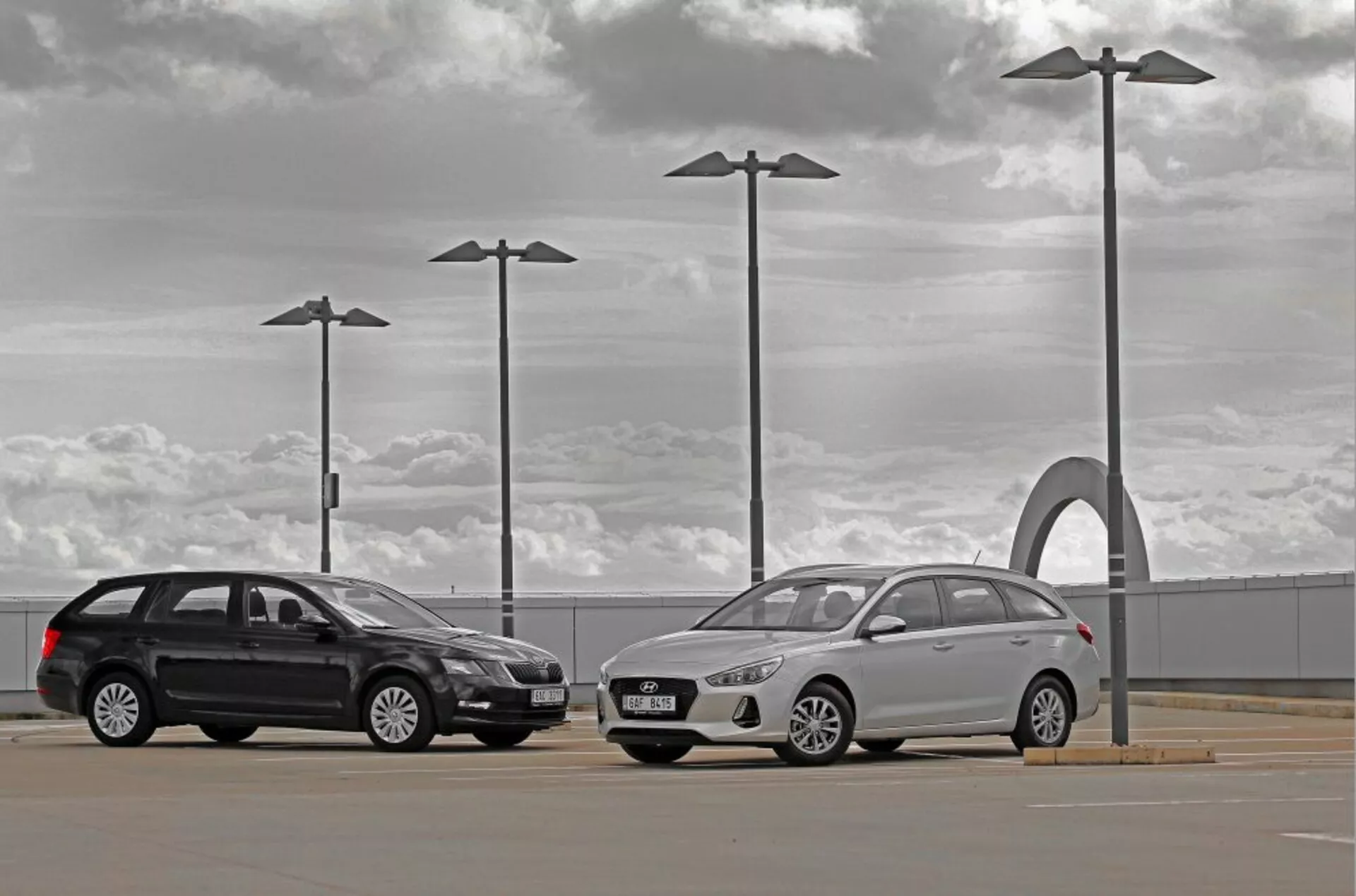 Hyundai i30 2017 kombi a sedan na venkovním parkovišti pod zamračenou oblohou s prvky městského designu
