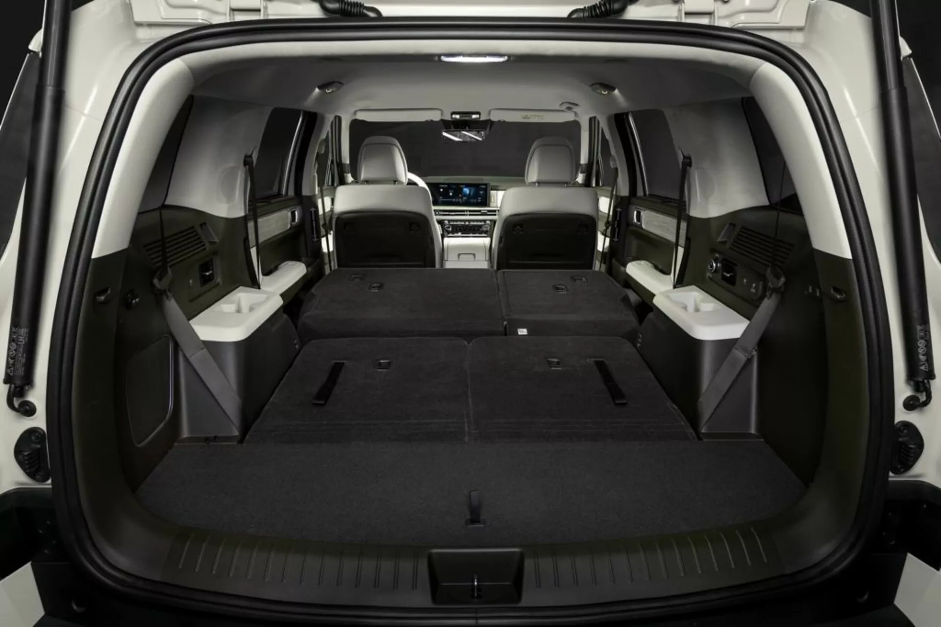 Interiér zavazadlového prostoru SUV Hyundai Santa Fe 2024 (5. generace) se sklopenými zadními sedadly, zdůrazňující prostorný kufr a flexibilní sedadla. Střední řada sedadel je kožená, snímek je z hotla zezadu a zvýrazňuje hloubku a užitnost zavazadlového prostoru.