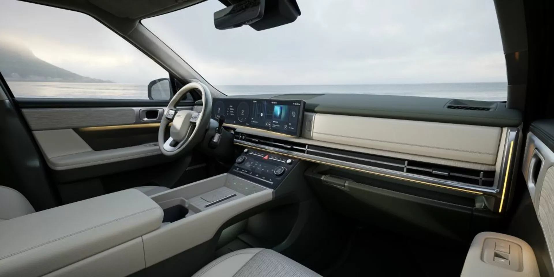 Širokoúhlý pohled na interiér Hyundai Santa-Fe 2024 (5. generace) ze zadního sedadla směrem k palubní desce, zdůrazňující luxus a pokročilou technologii. Obsahuje multifunkční infotainment systém s velkým, kontinuálním displejem, minimalistická tlačítka klimatizace, volant ovládaný tlačítky, digitální přístrojový panel (není vidět) a možná panoramatické čelní sklo naznačující vysoce kvalitní design s koženým a dřevěným nebo kovovým obložením.