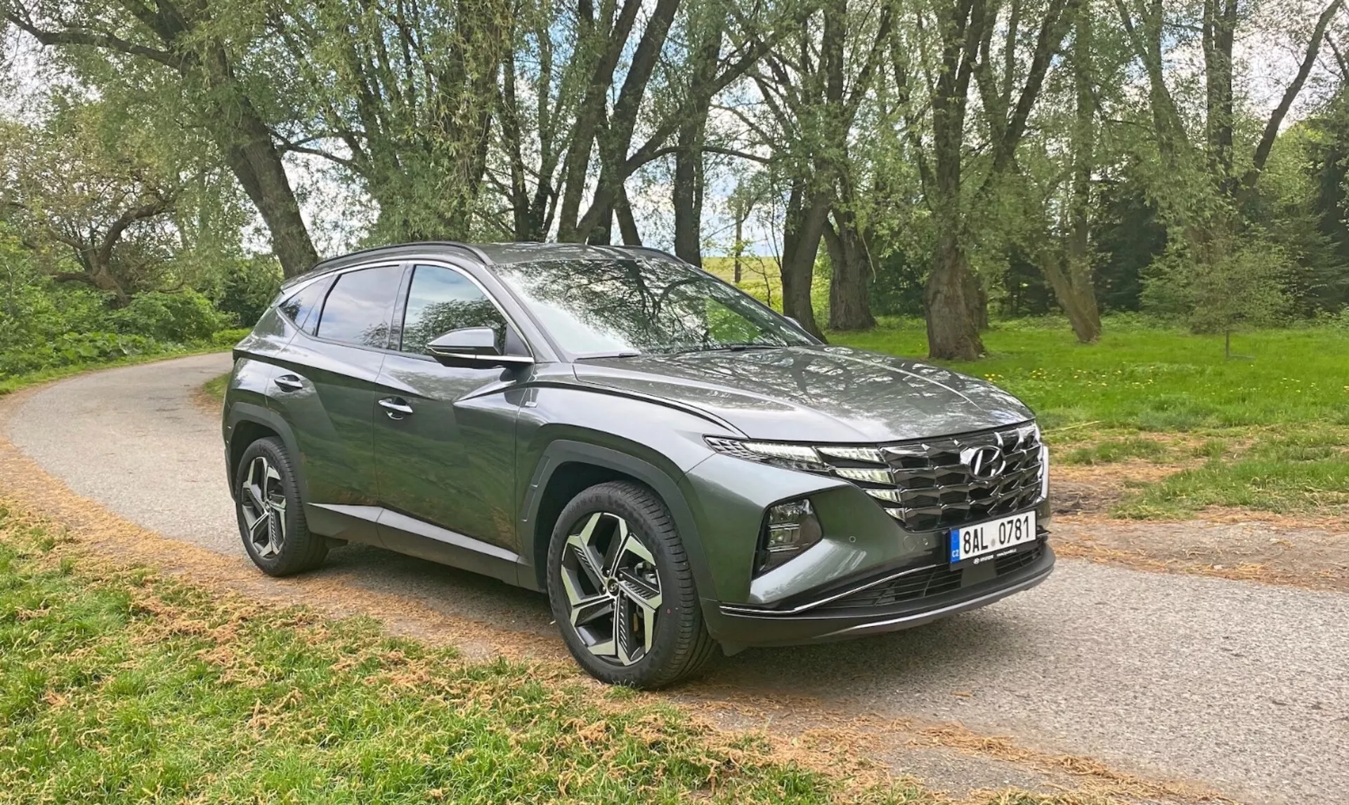 Hyundai Tucson 1.6 T-GDI Pure z roku 2020 v bezvadné bílé barvě, předvádící svůj elegantní design a moderní prvky na malebné horské silnici.
