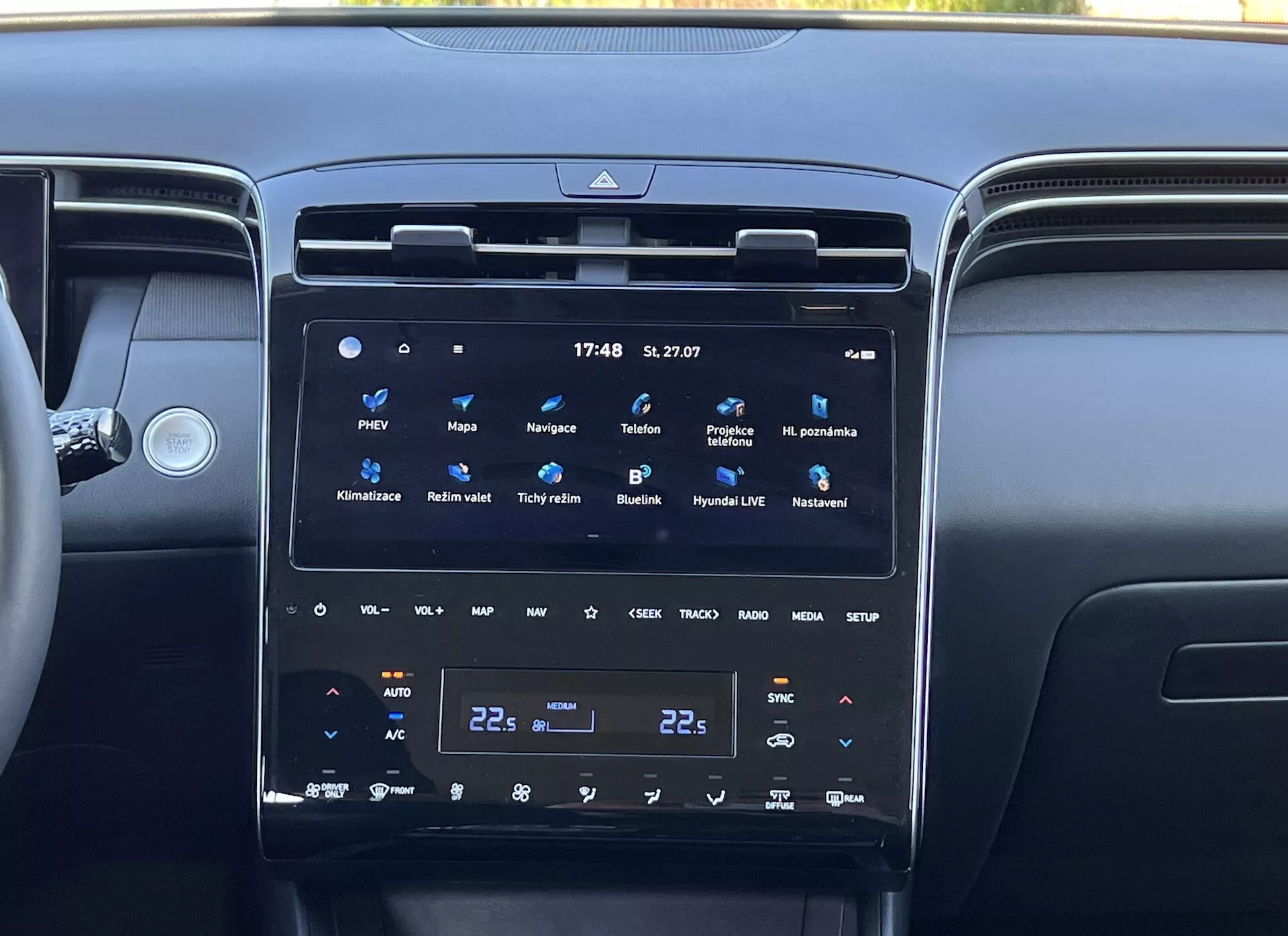 Interiér Hyundai Tucson 2020 ukazující středovou konzoli s velkým, vertikálním dotykovým displejem informačního systému, klimatizací s dvojzónovou regulací a okolními větracími otvory, odrážející moderní technologie a luxus vozidla