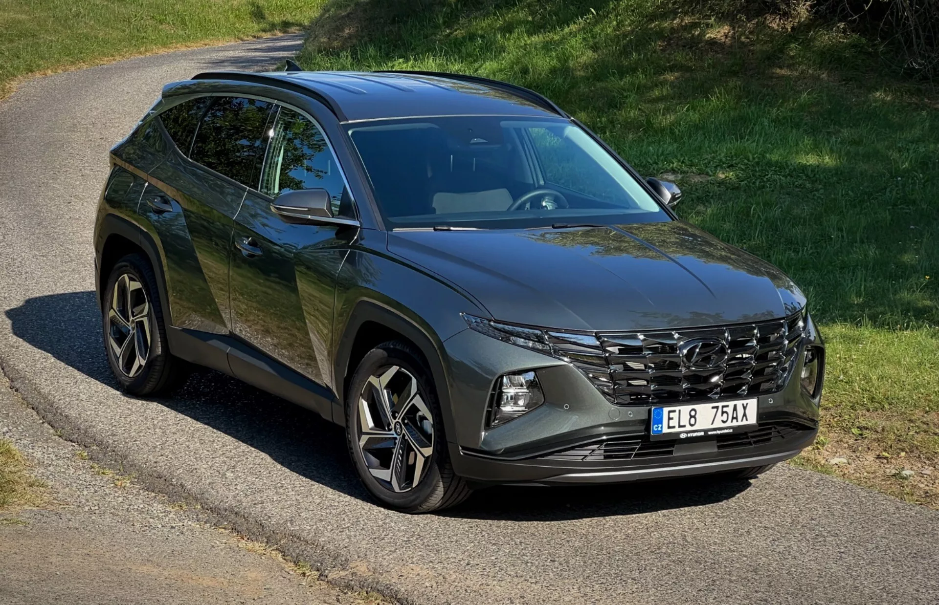 SUV Hyundai Tucson 2020 zaparkované na opuštěné silnici prezentující jeho přední mřížku, LED světlomety, slitinová kola a linie karoserie pod přirozeným slunečním světlem