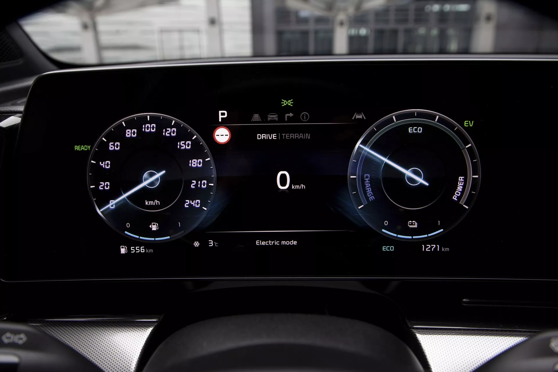 Detailní pohled na digitální palubní desku Kia Sportage NQ5 2022 s dvojitým displejem pro rychlost a výkon, ukazatelem spotřeby energie, stavem tachometru, indikátorem elektrického režimu a kvalitním provedením konzole