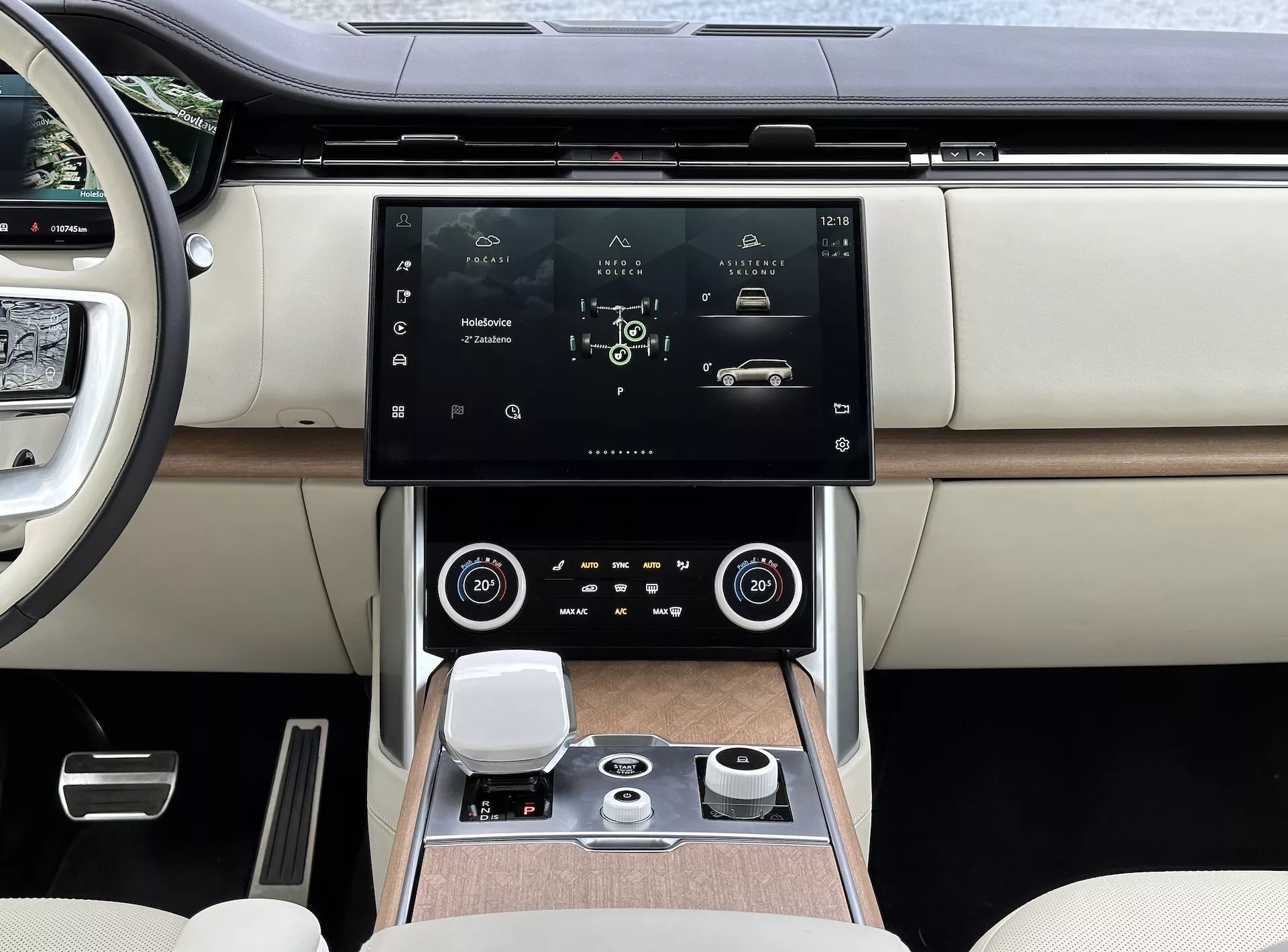 Land Rover Range Rover 2021 s moderním interiérem, zaměřeným na středovou konzoli a systém infotainmentu s vysokým rozlišením dotykové obrazovky, vzduchové mřížky s chromovými akcenty, duální klimatizaci, otočný ovládací knoflík pro navigaci systému a luxusní sedadla z kůže ve dvoutónovém provedení s dřevěnými detaily.