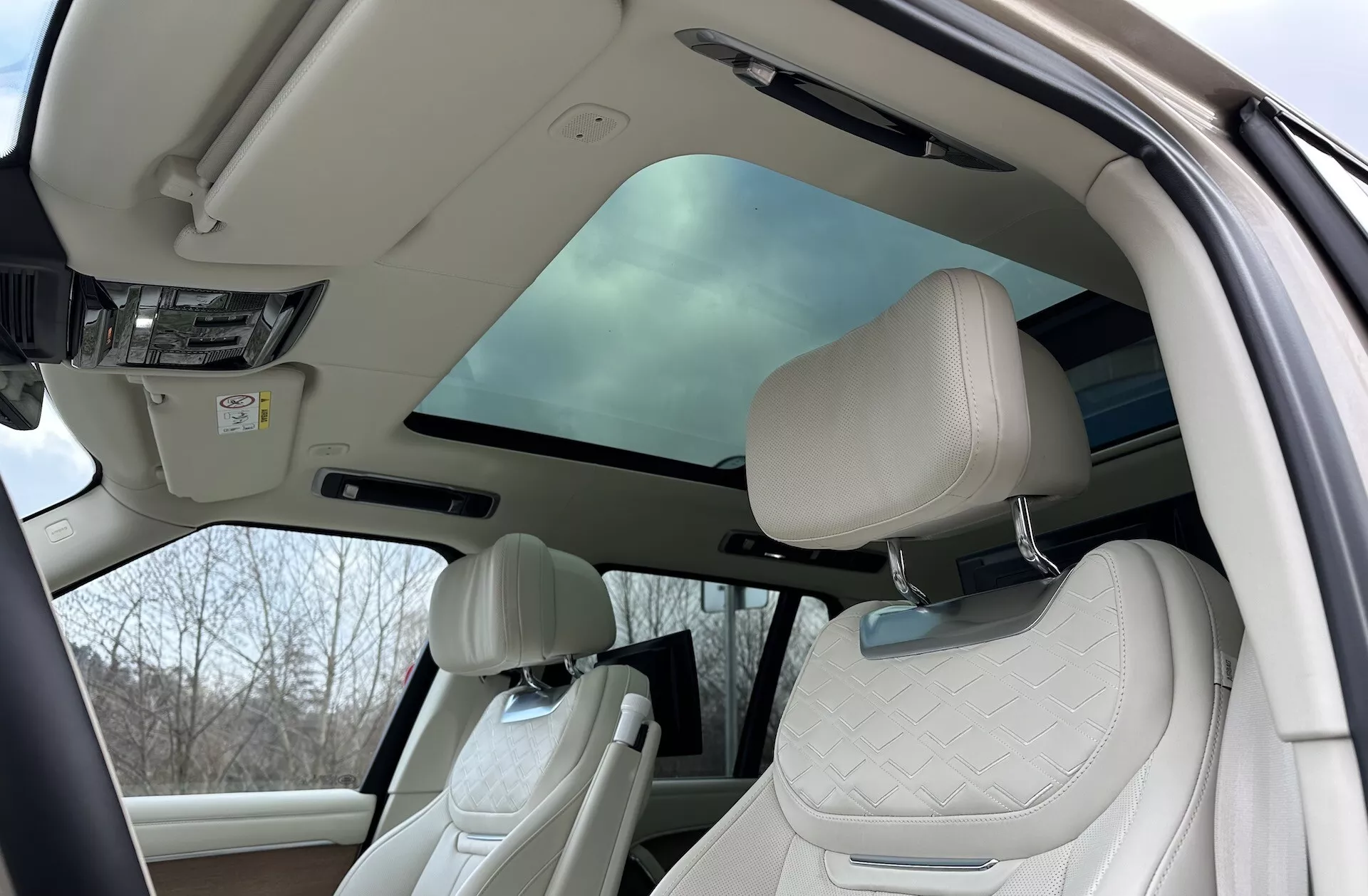 Interiér Land Rover Range Rover 2021 s pohledem na luxusní kabinu s panoramatickou střechou, čalouněním předních sedadel a pokročilými funkcemi kabiny