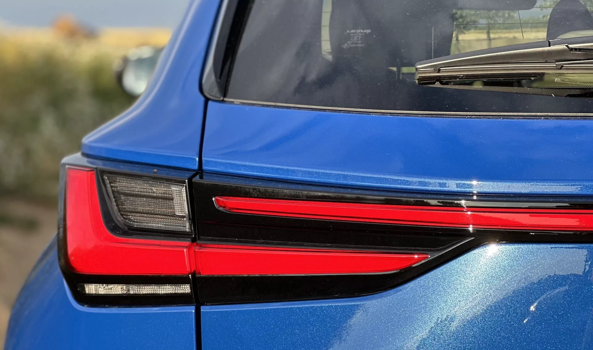 Detailní pohled z pravé zadní strany na Lexus NX 2021, který představuje moderní design LED zadního světla, odrážející jeho sofistikovanou technologii osvětlení a lesklou modrou povrchovou úpravu.