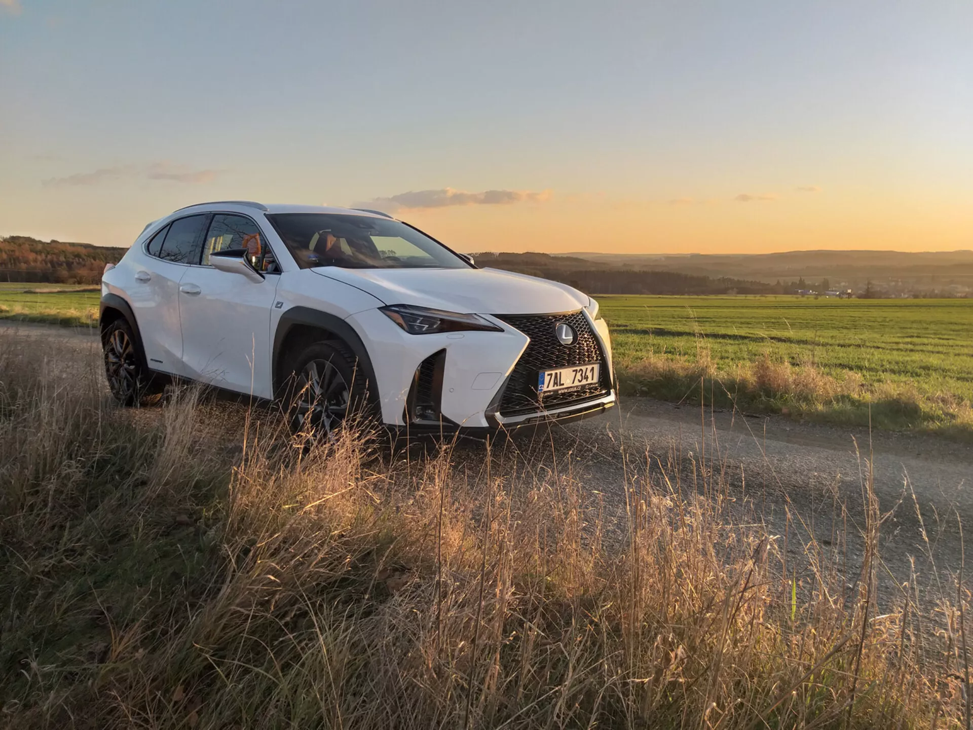Kompaktní luxusní crossover Lexus UX 2019 v pohybu na městské ulici, ukazuje jeho elegantní design a pokročilé funkce