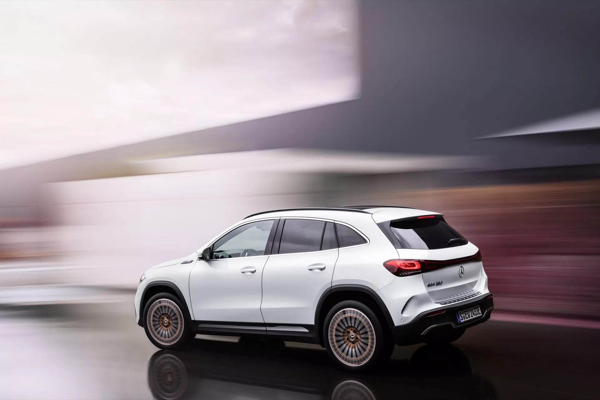 Mercedes-Benz EQA 2021, luxusní kompaktní SUV v pohybu, zobrazení zezadu ze tří čtvrtin s důrazem na dynamický design a pokročilé technologické funkce