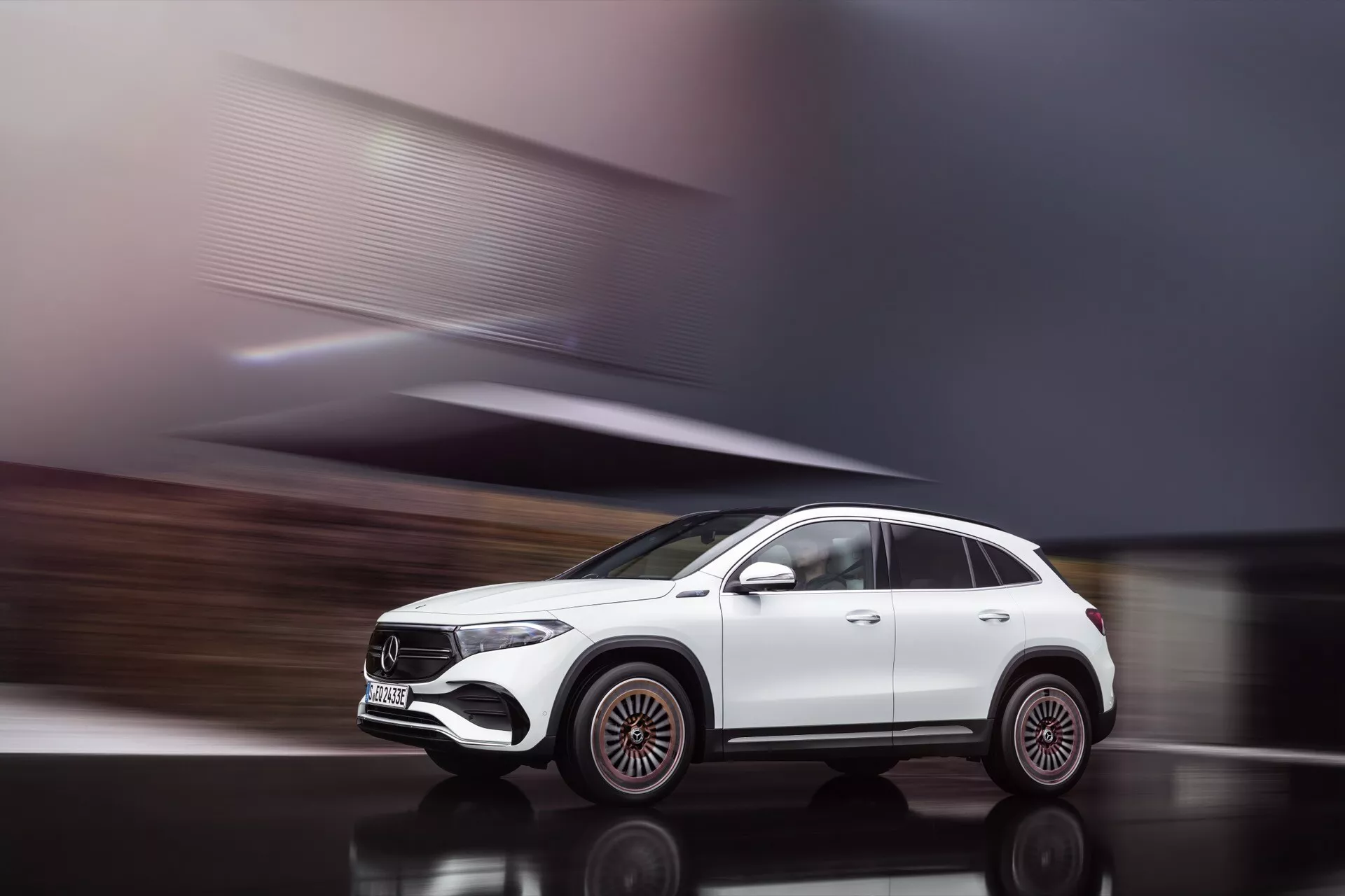 Dynamický profilový snímek bílého SUV Mercedes-Benz EQA 2021 v pohybu, ukazující výrazná velká slitinová kola, elegantní design světlometů a moderní aerodynamický exteriér