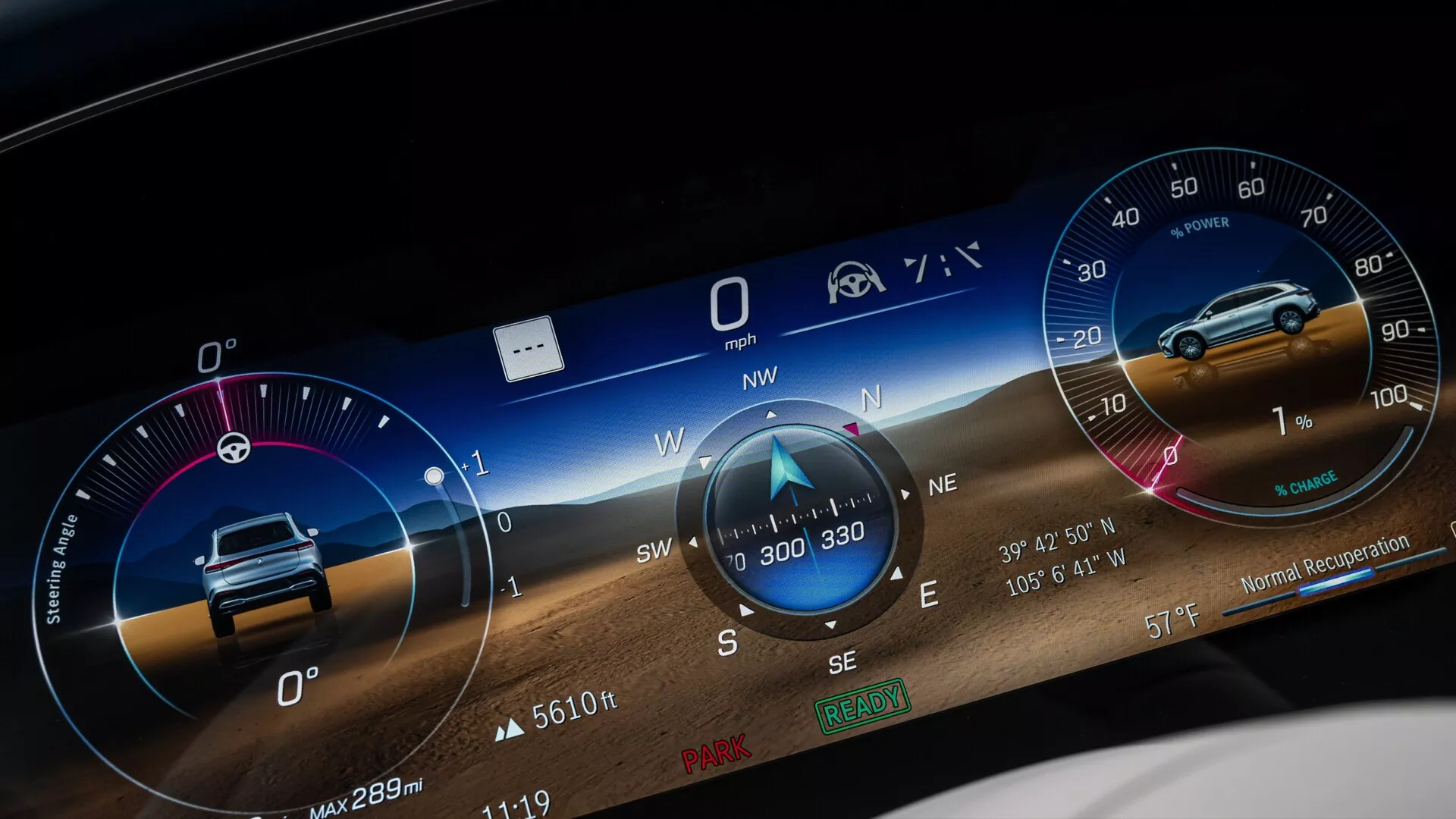 Detailní záběr digitálního přístrojového panelu Mercedes EQS SUV 2022 s širokoúhlým grafickým uživatelským rozhraním zobrazujícím různé metriky, jako je rychloměr na 0 mph, kompas směřující na severozápad, pravděpodobně otáčkoměr, informace o najetých kilometrech, například 'Max 289m,' a ikony pro připomenutí bezpečnostního pásu a asistenci řidiče. Pozadí zahrnuje dynamickou krajinu pro vizuální přitažlivost.