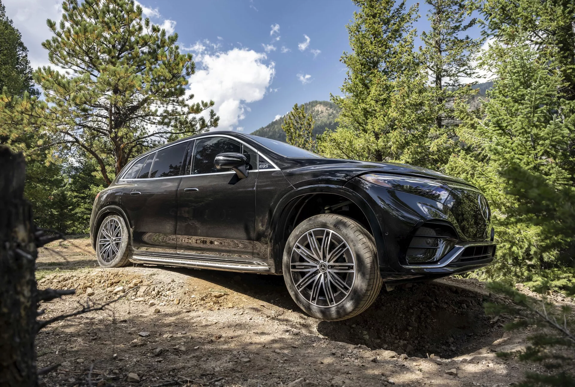 Přední tříčtvrtečný pohled na Mercedes EQS SUV 2022, zobrazující jeho elegantní design, pokročilé LED světlomety, panoramatickou střechu a prémiová hliníková kola v sofistikovaném městském prostředí.