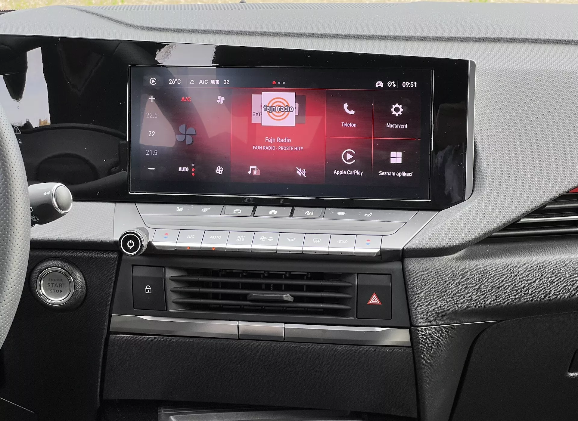 Pohled na palubní desku Opel Astra 2022 zdůrazňující dotykovou obrazovku infotainmentu s kompatibilitou Apple CarPlay a Android Auto, systém klimatizace a detailní design kabiny