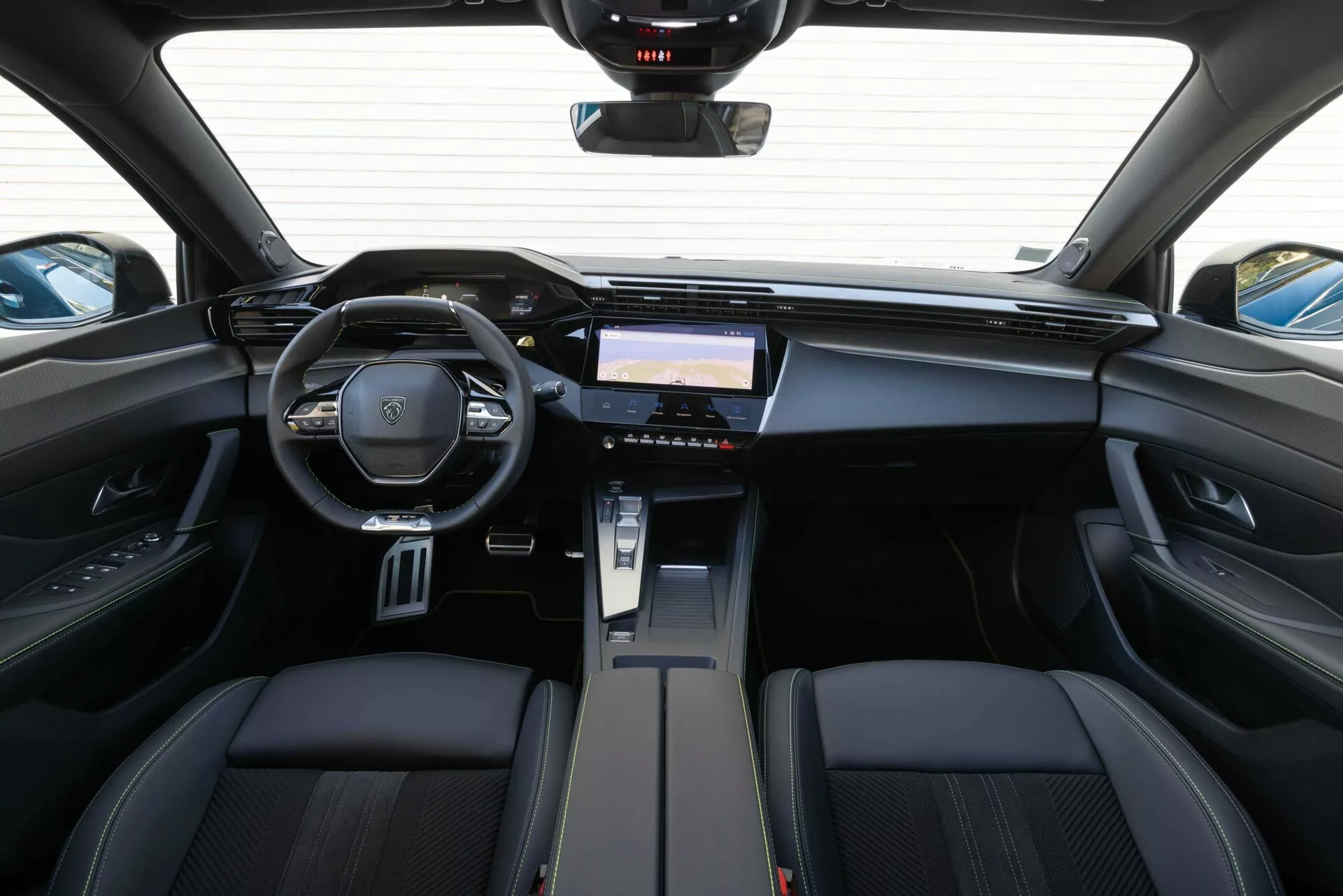 Interiér Peugeotu 408 z roku 2023 z pohledu ze zadního sedadla zdůrazňuje palubní desku, multifunkční volant se znakem značky a pokročilý informačně-zábavní systém