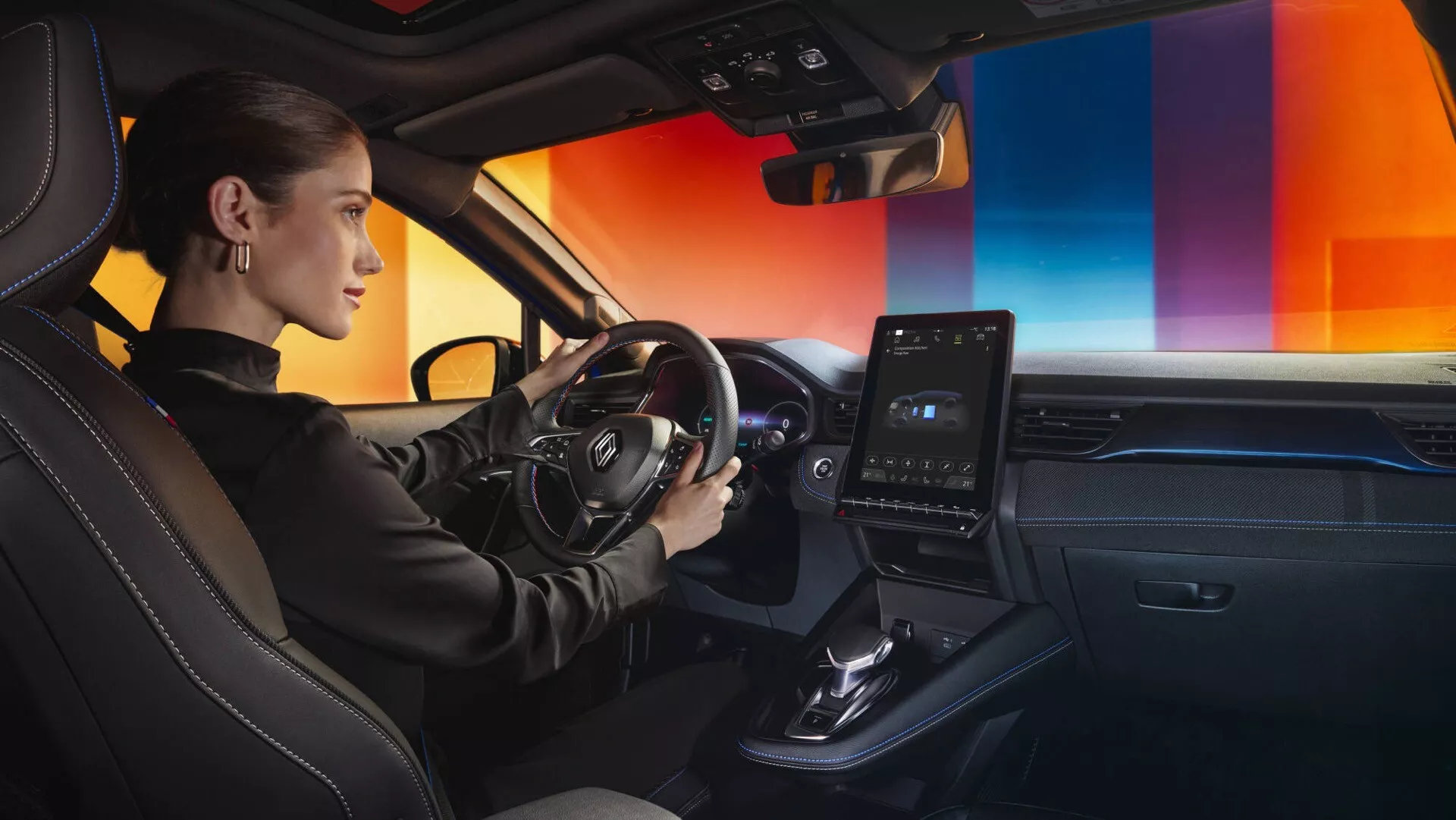 Interiér Renault Captur II Facelift 2024 s pohledem na stranu řidiče se zaměřením na ovládací prvky na volantu, elegantní palubní desku s vertikálním dotykovým informačním systémem a prémiová kožená sedadla